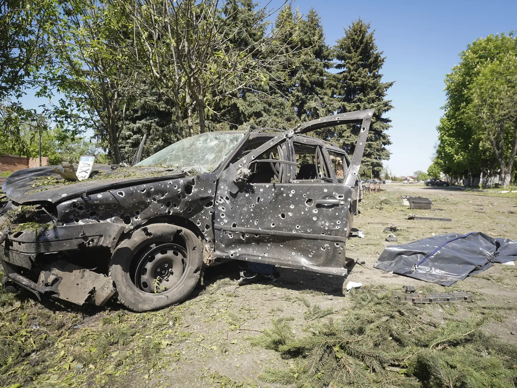 Telo muža, ktorý prišiel o život pri útoku ruskej armády, je prikryté v centre mesta Zoločiv v Charkovskej oblasti približne 15 kilometrov od hraníc s Ruskom  v stredu 1. mája 2024.