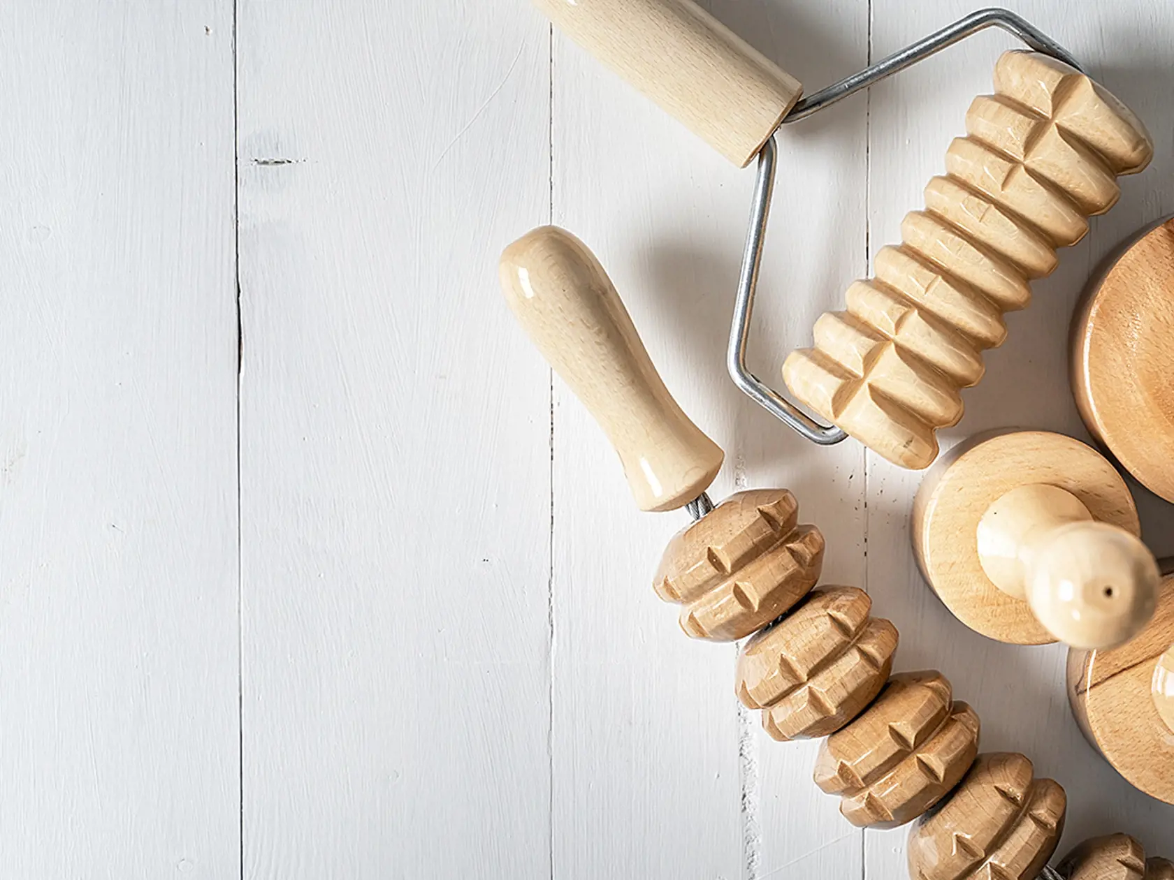 Wood massage maderotherapy madero therapy wooden rolling pin or battledore tools for anti cellulite treatment to stimulate the lymphatic system and improve circulation concept copy space top view