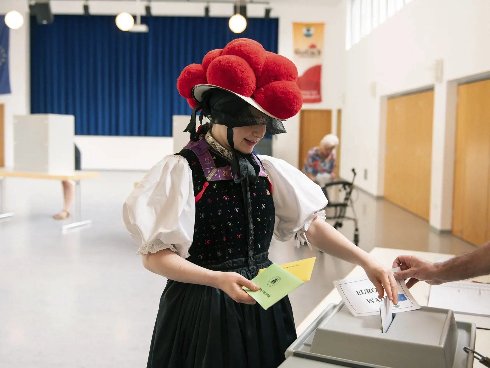 Katharina Moserová, oblečená v tradičnom schwarzwaldskom kroji s červeným klobúkom, hlasuje počas volieb do Európskeho parlamentu v nemeckom Potsdame v nedeľu 9. mája 2024. Eurovoľby sa konali od 6. do 9. júna.