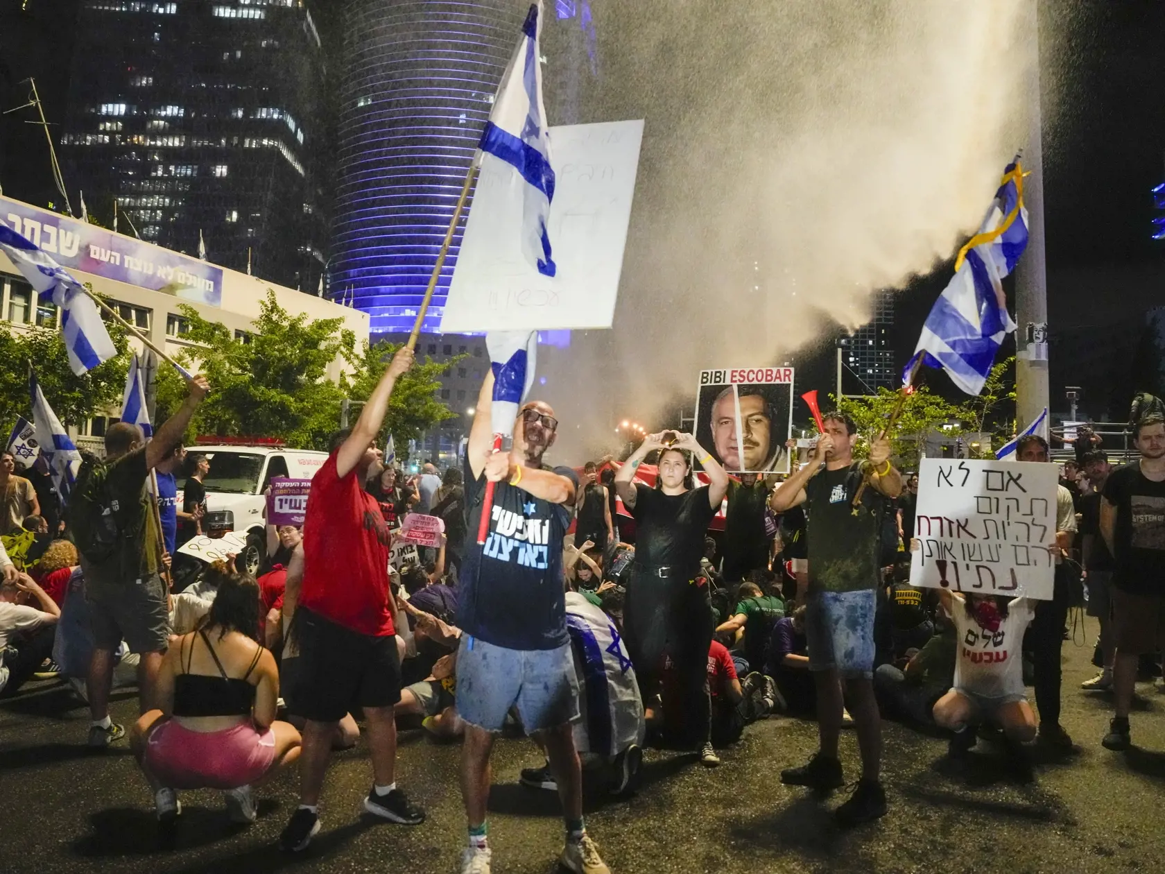 Policajti používajú vodné na rozohnanie davu počas protivládneho protestu v Tel Avive v sobotu 8. júna 2024. Demonštranti vyzývali na prijatie dohody o prepustení zvyšných zajatcov odvlečených militantmi do Pásma Gazy po vlaňajšom útoku na Izrael. Na demonštrácii v Tel Avive sa strhla potýčka s políciou, keď sa protestujúci pokúsili zablokovať diaľnicu. Podľa izraelských médií polícia na rozohnanie davu použila vodné delá.