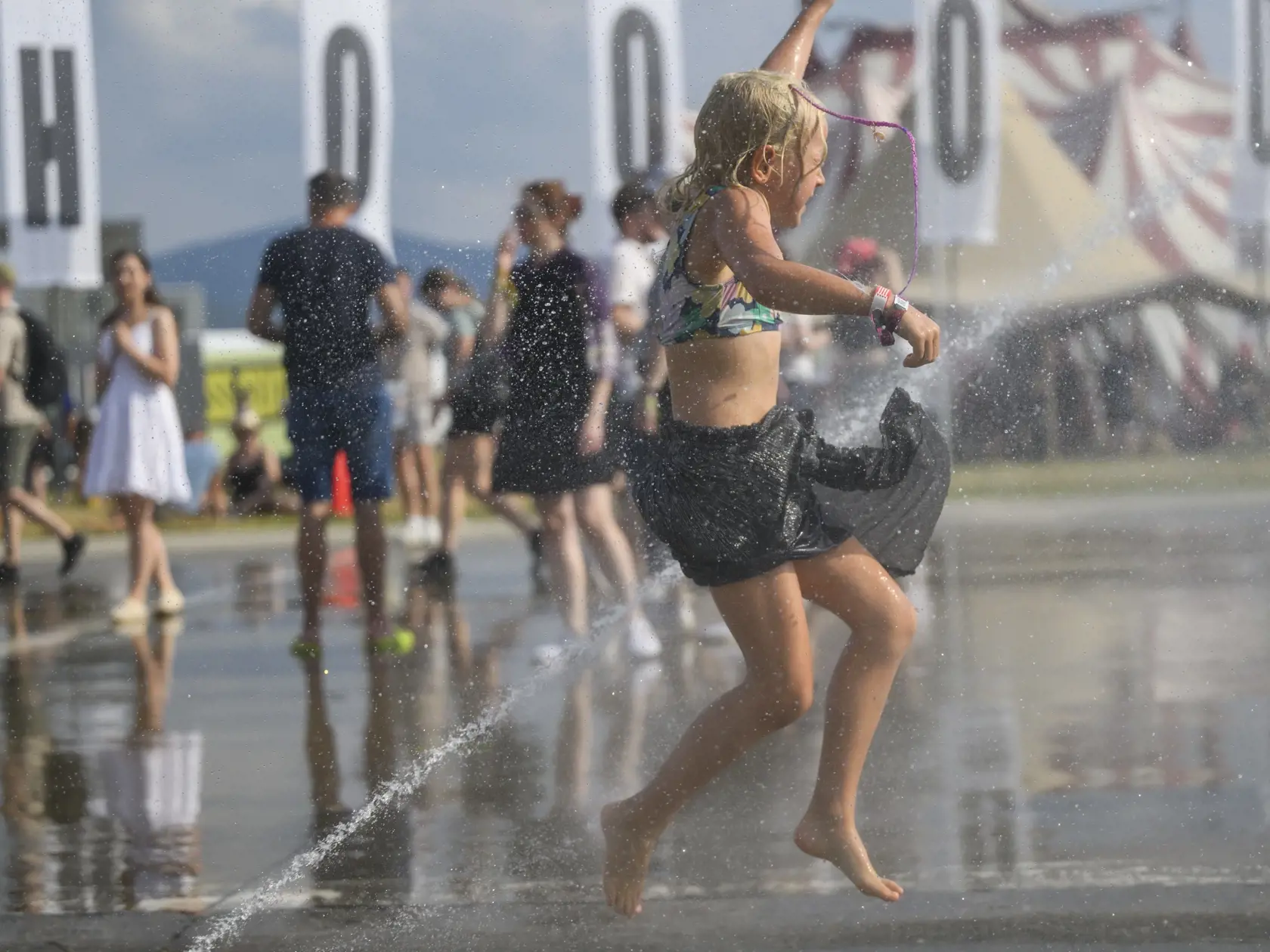 Na snímke ľudia sa osviežujú počas druhého dňa 27. ročníka festivalu Pohoda v piatok 12. júla 2024 v Trenčíne.