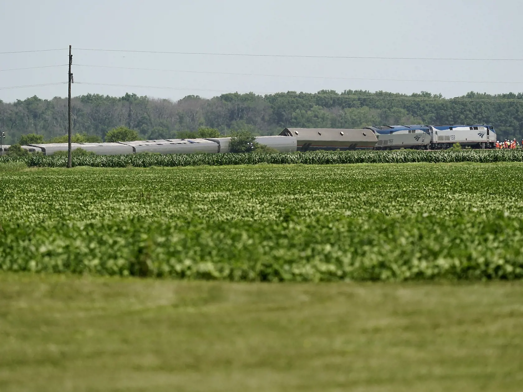 PK 38 Mendon - Vagóny vlaku amerického železničného prepravcu Amtrak ležia prevrátené pri trati po vykoľajení pri meste Mendon v americkom štáte Missouri 28. júna 2022. Vlak smerujúci do Chicaga sa vykoľajil po zrážke s nákladným vozidlom. FOTO TASR/AP

Workers gather at the front of a derailed Amtrak train Tuesday, June 28, 2022, near Mendon, Mo. The Chicago-bound train derailed Monday after striking a dump truck. (AP Photo/Charlie Riedel)