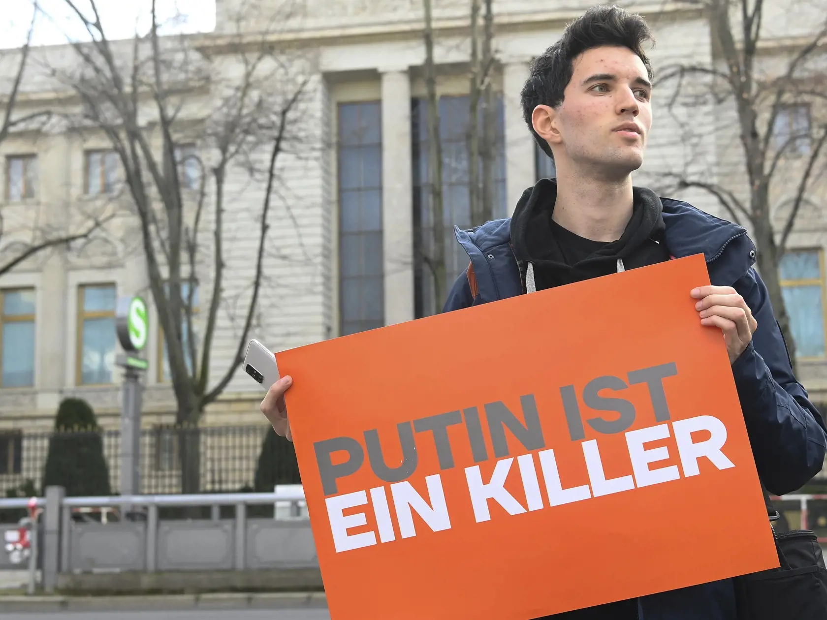 Muž drží transparent s nápisom Putin je vrah pred ruským veľvyslanectvom v Berlíne v piatok 16. februára 2024.