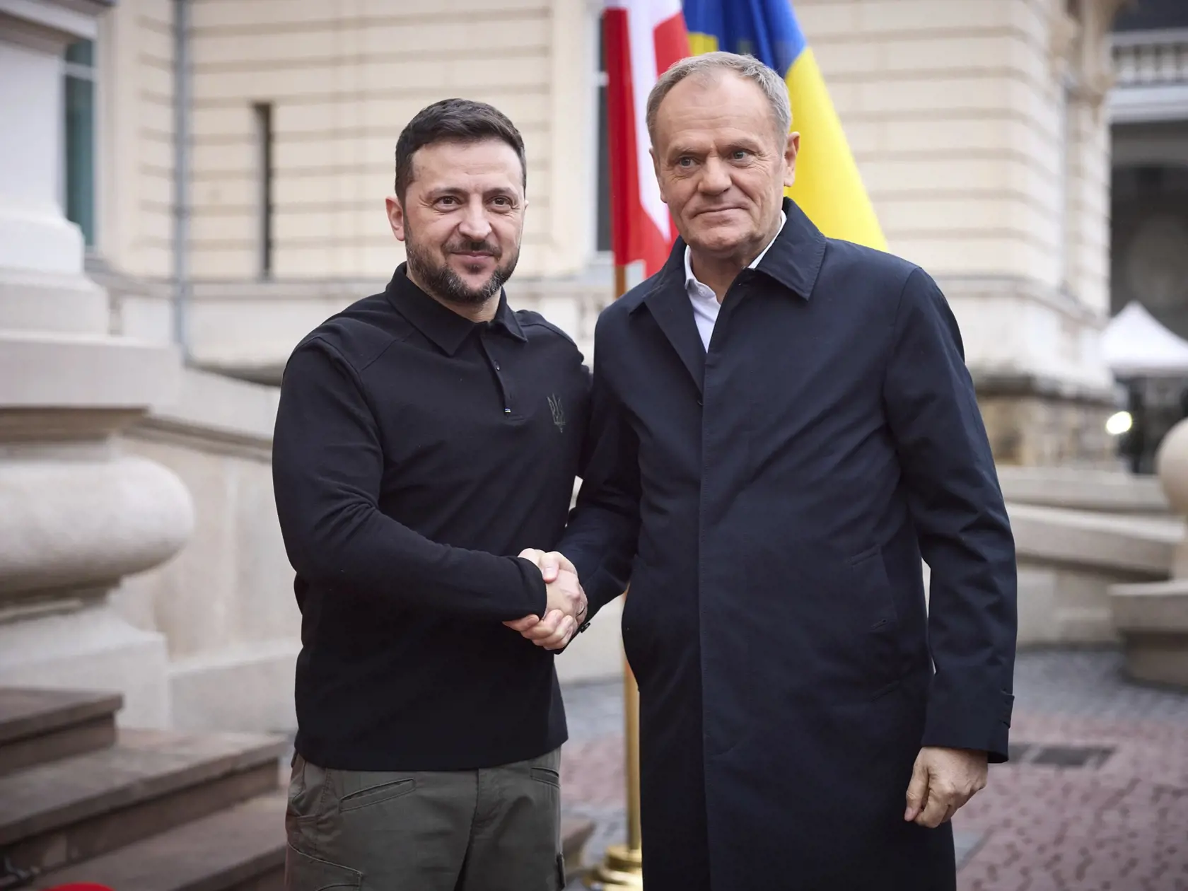 Ukrajinský prezident Volodymyr Zelenskyj (vľavo) a poľský premiér Donald Tusk si podávajú ruky počas stretnutia v západoukrajinskom meste Ľvov.