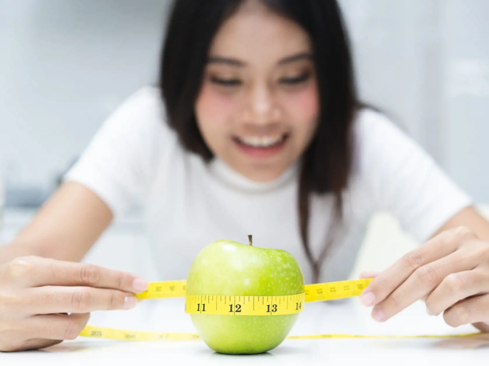 Slimming,And,Dieting,Concept.,Woman,Measuring,Green,Apple.