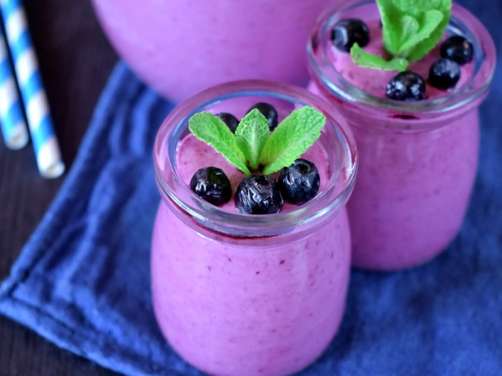 Blueberry,Smoothie,In,Glass,Jars,Topped,With,Berries,And,Mint