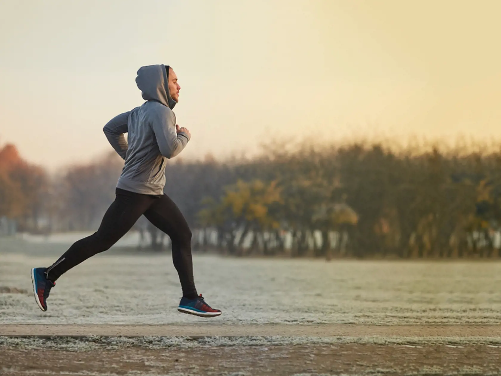 Young,Athletic,Man,Running,At,Park,During,Cold,Autumn,Morning