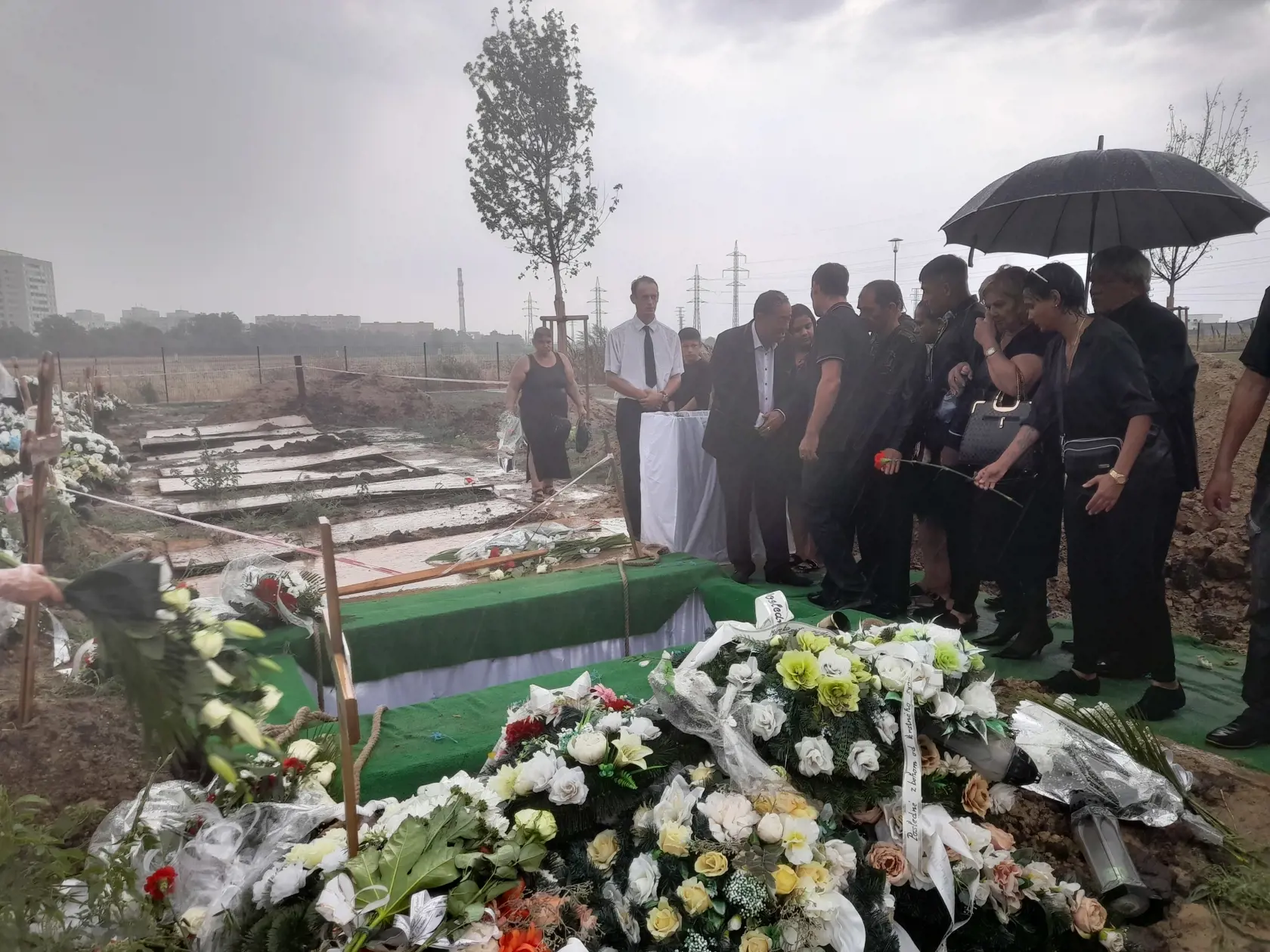 Žena hádže červenú ružu na rozlúčku s Kamilom Polakovičom v obrovskom lejaku.
