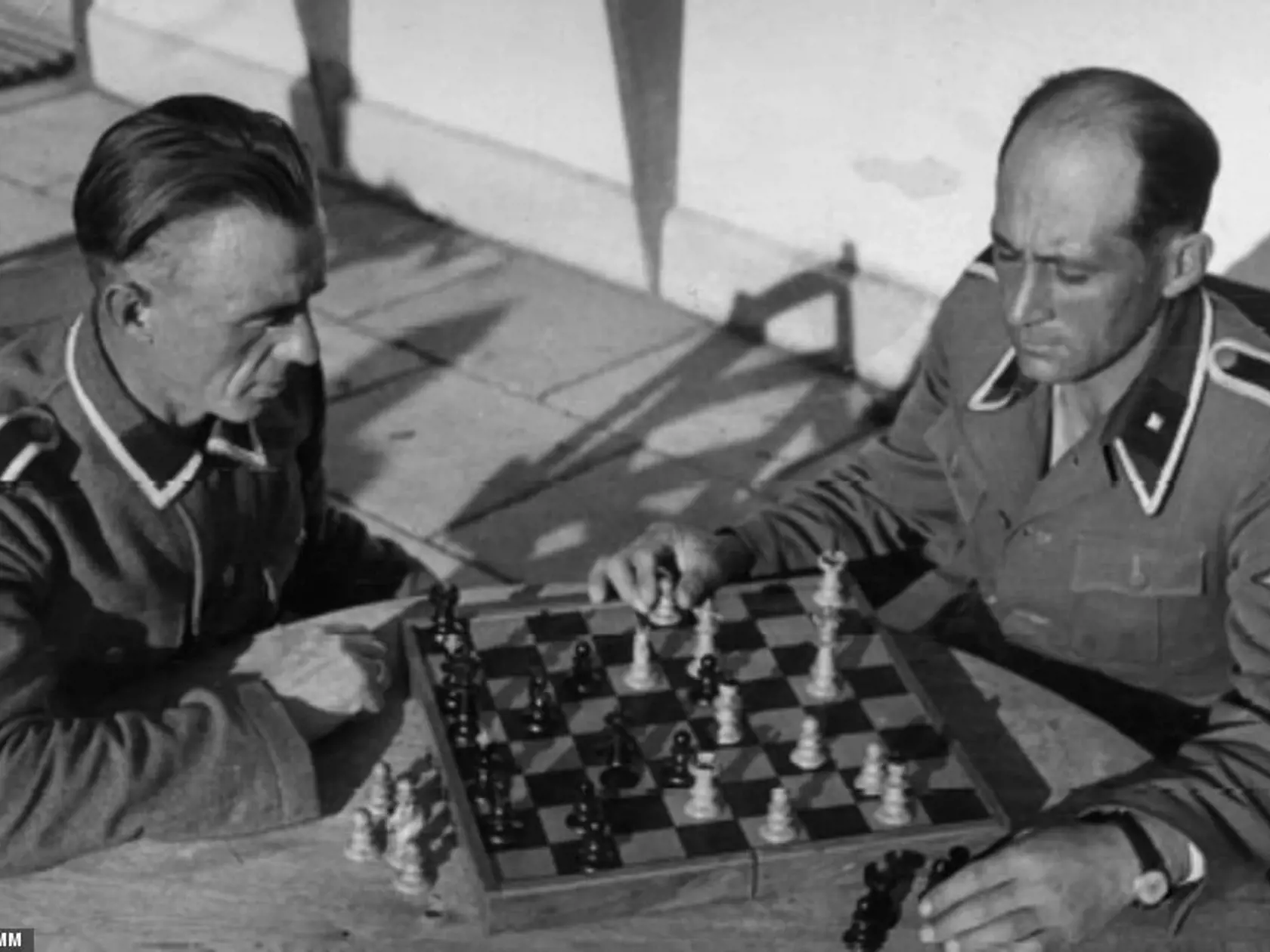 Úradníci SS Willi Wendland (vľavo) a Franz Wolf hrajú šach pred jedálňou nových dôstojníkov v Sobibore v roku 1943.