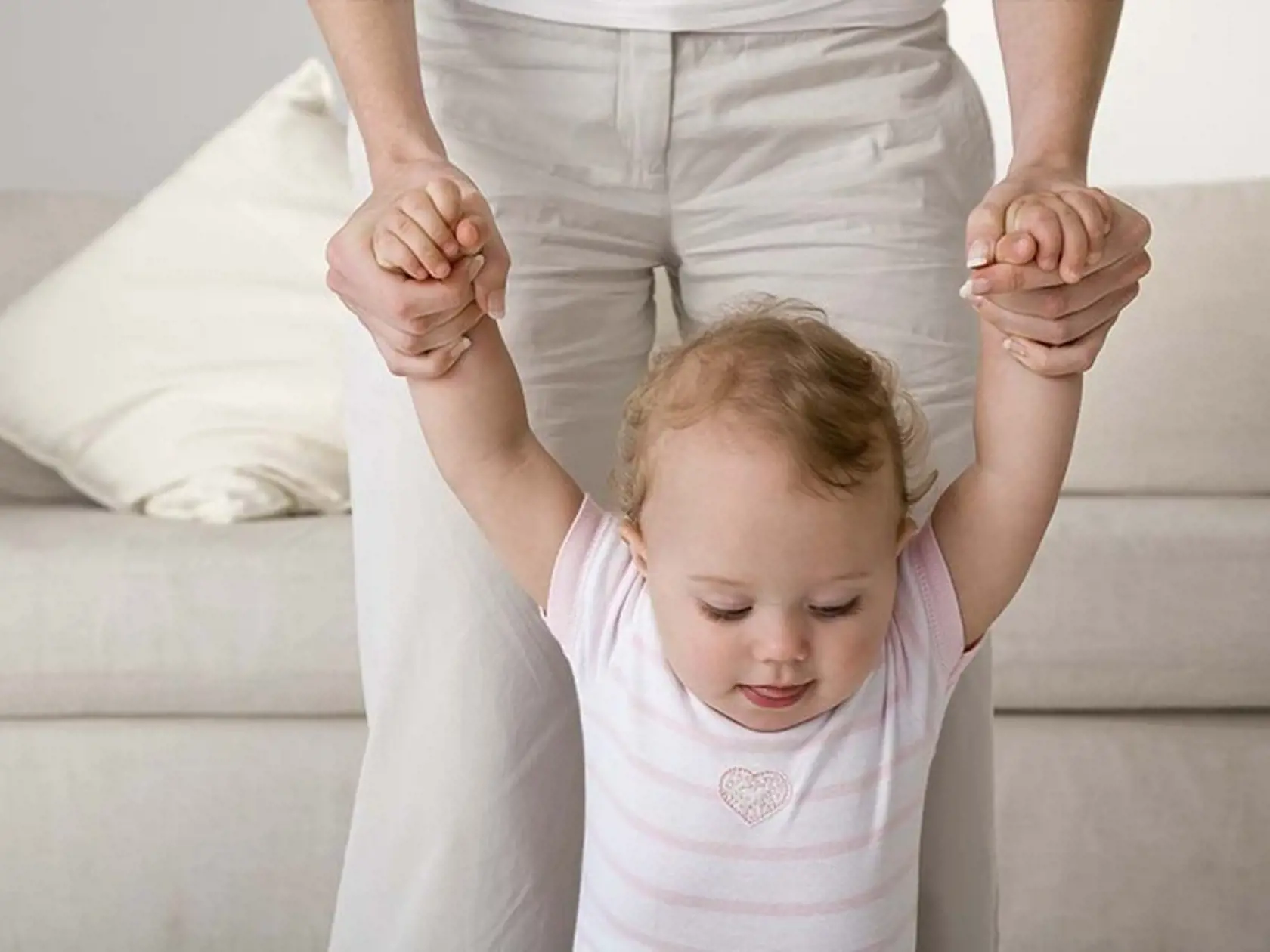 Mother helping baby walk