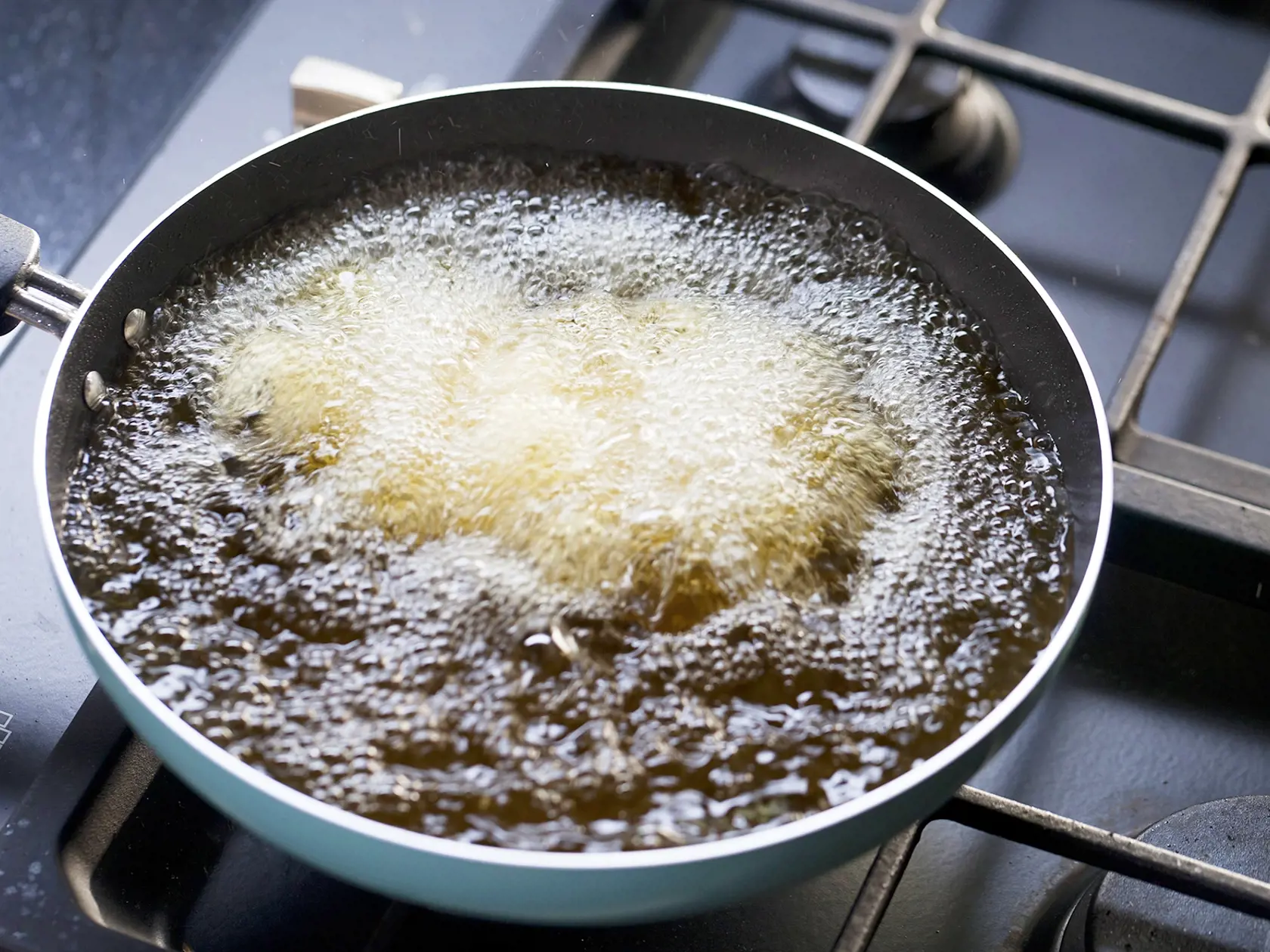 frying pan with boiling oil on the stove.