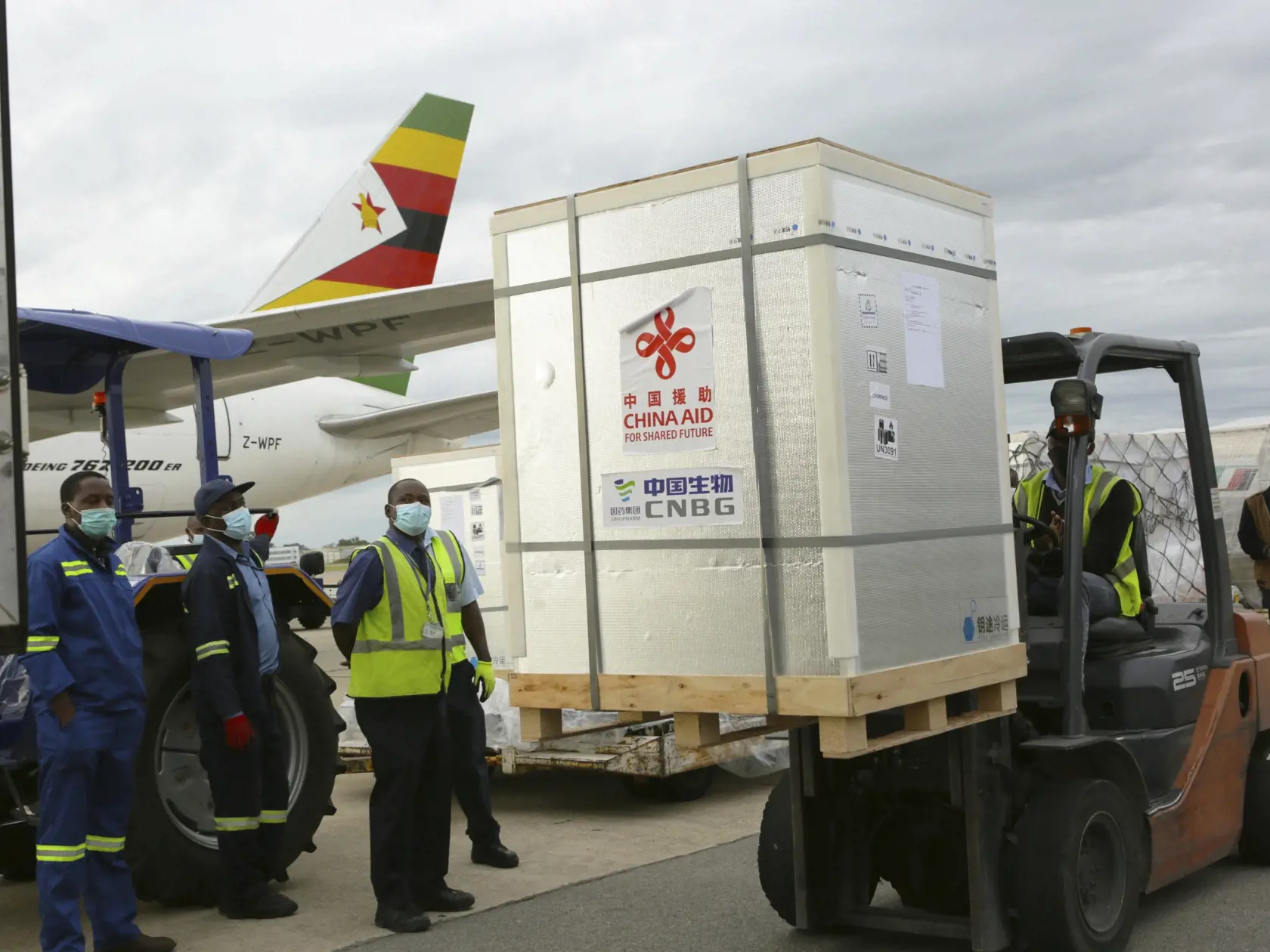 KK38 Harare - Vykladanie prvej dodávky vakcíny od čínskej firmy Sinopharm proti ochoreniu Covid-19 na letisku v Harare 15. februára 2021. Zimbabwe dostalo vôbec prvú dodávku vakcín proti ochoreniu COVID-19, ktoré tejto africkej krajine darovala Čína.  Dovedna 200.000 dávok očkovacích látok od čínskej firmy Sinopharm prevzal v pondelok ráno na letisku v Harare zimbabwiansky viceprezident a minister zdravotníctva Constantino Chiwenga. FOTO TASR/AP
A forklift moves part of the Sinopharm COVID-19 va