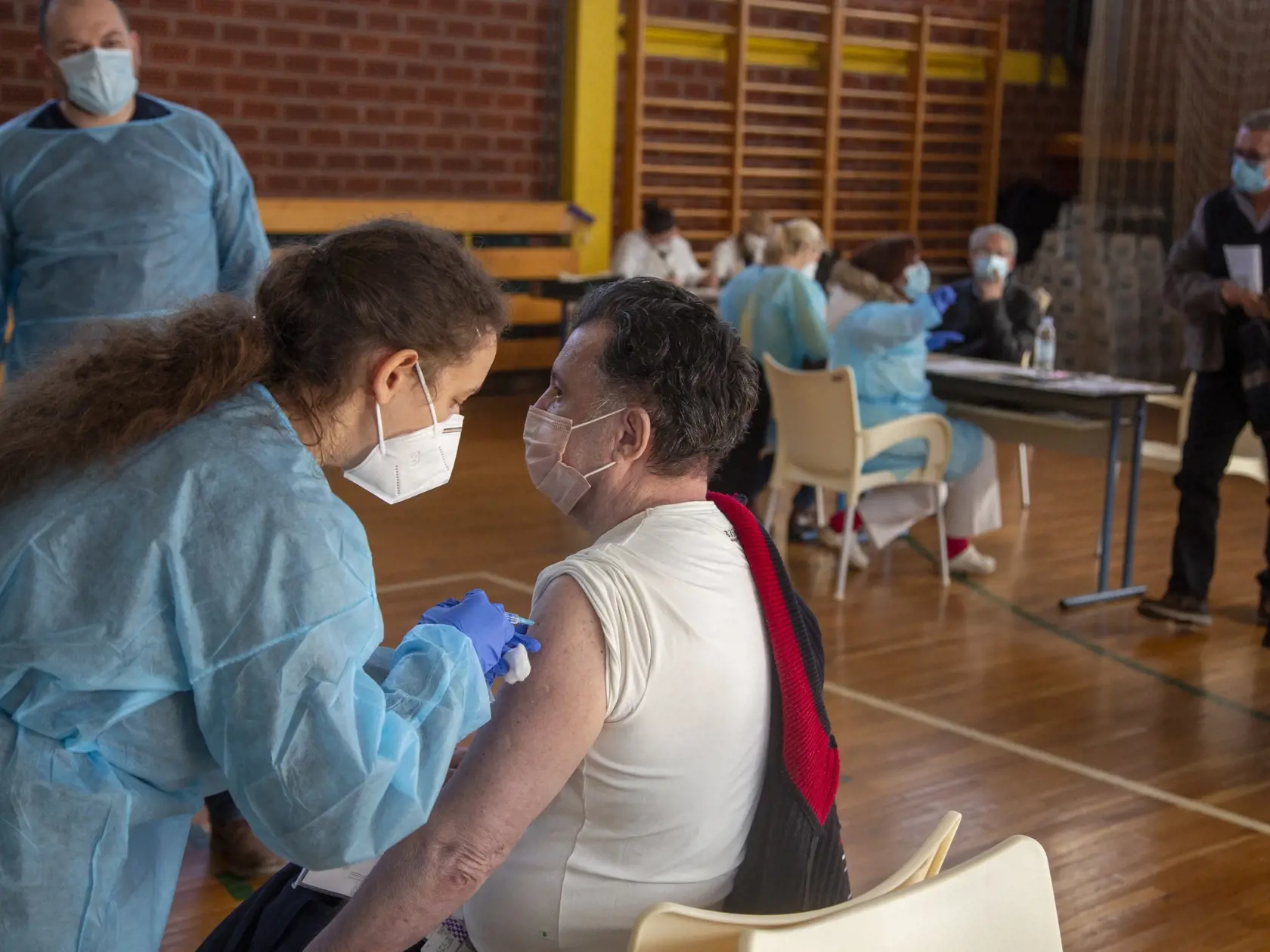 KK21 Záhreb - Na snímke muž dostáva vakcínu od konkorzia Pfizer/Biontech počas očkovania proti koronavírusu v športovej hale 23. februára 2021 v Záhrebe. V utorok sa v chorvátskom hlavnom meste začala masívna očkovacia kampaň, počas ktorej sa vytvorili dlhé rady ľudí čakajúcich na prvé dávky vakcíny proti novému koronavírusu. FOTO TASR/AP
A man receives a Pfizer coronavirus vaccine at a sports hall in Zagreb, Croatia, Tuesday, Feb. 23, 2021. Long lines of people waiting to receive the first shot