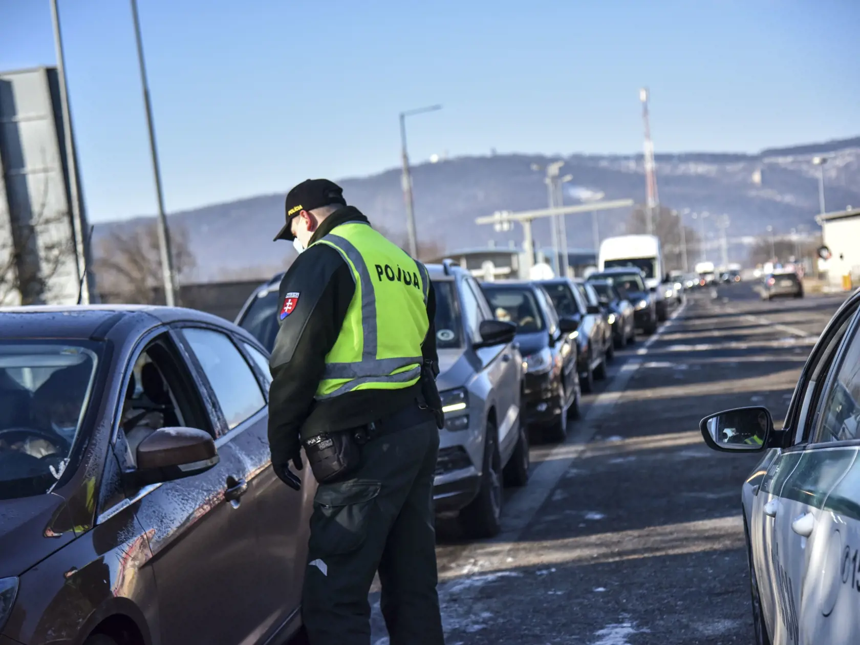 Na snímke policajt vykonáva hraničnú kontrolu pri vstupe na Slovensko na slovensko - rakúskom hraničnom priechode Bratislava - Berg, 15. februára 2021. Policajti kontrolujú dodržiavanie karanténnych opatrení a splnenie podmienok pred vstupom na územie Slovenska vyplývajúcich z platnej vyhlášky Úradu verejného zdravotníctva SR. FOTO TASR - Pavol Zachar