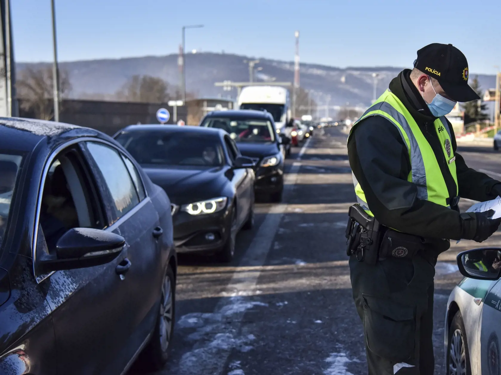 Na snímke policajt vykonáva hraničnú kontrolu pri vstupe na Slovensko na slovensko - rakúskom hraničnom priechode Bratislava - Berg, 15. februára 2021. Policajti kontrolujú dodržiavanie karanténnych opatrení a splnenie podmienok pred vstupom na územie Slovenska vyplývajúcich z platnej vyhlášky Úradu verejného zdravotníctva SR. FOTO TASR - Pavol Zachar