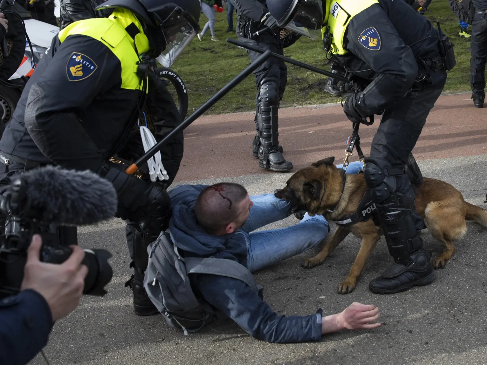 Holandskí policajti zatýkajú muža počas protestu proti nočnému zákazu vychádzania, obmedzeniam pohybu a protipandemickým opatreniam v Haagu v nedeľu 14. marca 2021.