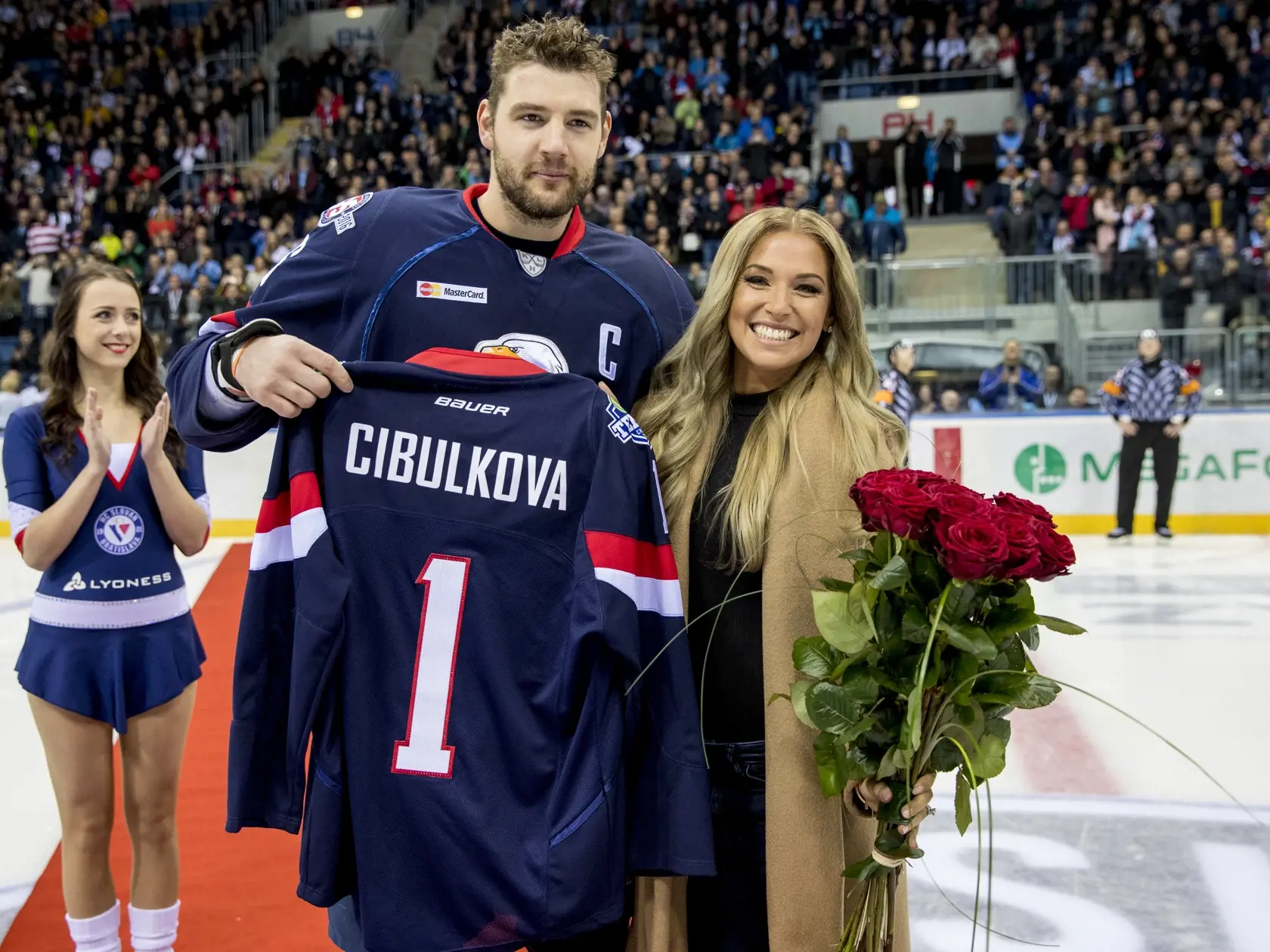 Na snimke slovenska tenistka Dominika Cibulkova vhodila uvodne buly pocas zapasu Kontinentalnej hokejovej ligy medzi HC Slovan Bratislava a Dinamom Riga. Od Andreja Meszarosa dostala Dominika dres s cislom 1.