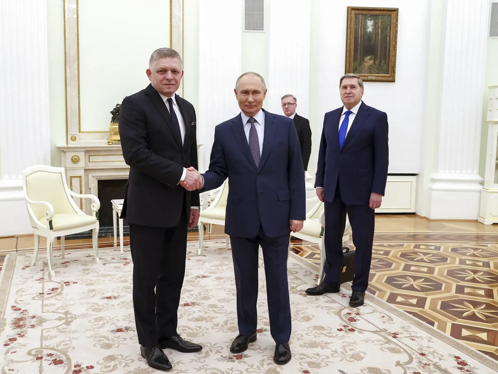 Ruský prezident Vladimir Putin (v popredí vpravo) a slovenský premiér Robert Fico (vľavo) si podávajú ruky počas stretnutia v Moskve 22. decembra 2024.