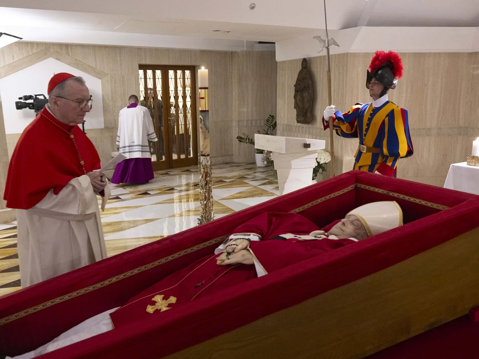 Vatikánsky štátny sekretár kardinál Pietro Parolin (vľavo) sa modlí nad telom  zosnulého pápeža Františka, ktoré je vystavené v otvorenej rakve v súkromnej kaplnke vo Vatikáne v pondelok 21. apríla 2025.