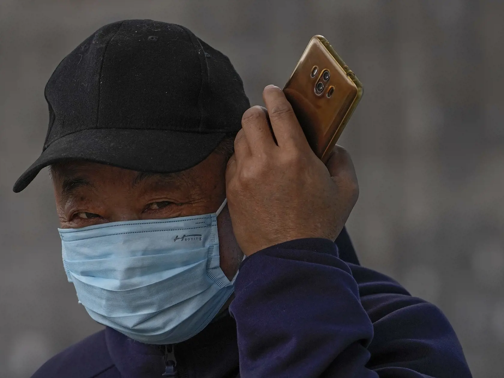 WA 31 Peking - Muž s ochranným rúškom proti šíreniu ochorenia COVID-19 počúva mobilný telefón na ulici v Pekingu vo štvrtok 28. októbra 2021. FOTO TASR/AP 

A man wearing a face mask to help curb the spread of the coronavirus listens to his smartphone on a street in Beijing, Thursday, Oct. 28, 2021. (AP Photo/Andy Wong)