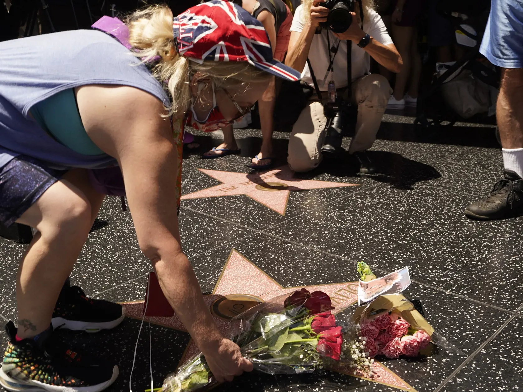 WA 48 Los Angeles - Ľudia kladú kvety na hviezdu austrálskej speváčky a herečky Olivie Newton-John na Hollywoodský chodník slávy v Los Angeles v pondelok 8. augusta 2022. Herečka zomrela v pondelok vo veku 73 rokov. Celosvetovo sa preslávila rolou Sandy vo filmovom muzikále Pomáda, kde si zahrala po boku Johna Travoltu. Herečka prehrala 30-ročný boj s rakovinou prsníka. FOTO TASR/AP 

A fan honors actor Olivia Newton-John with flowers on Newton-John's Hollywood Walk of Fame star in Los Angeles, 