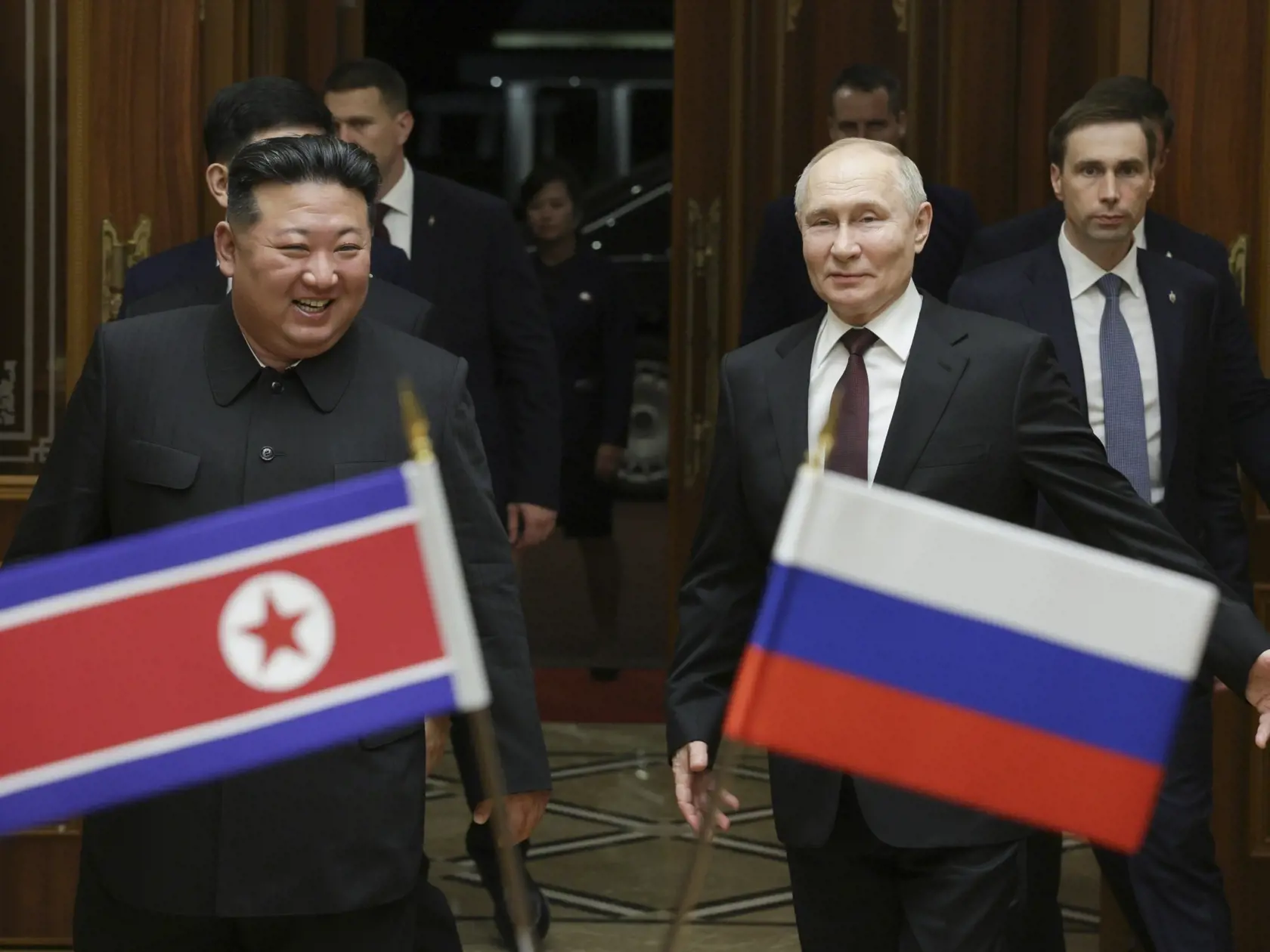 Ruský prezident Vladimir Putin (vpravo) a severokórejský vodca Kim Čong-un sa usmievajú počas stretnutia na letisku v Pchjongjangu 19. júna 2024.