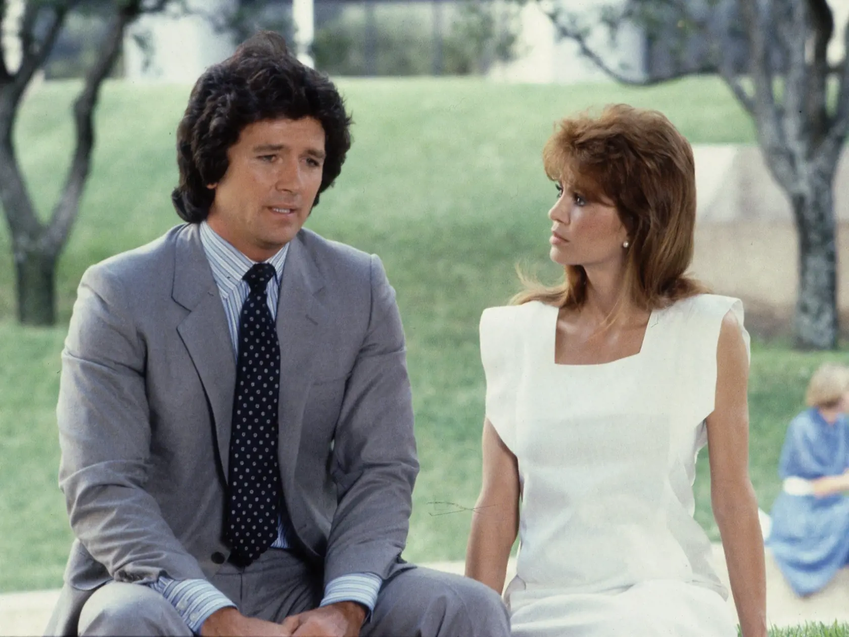 In a scene from the American television series 'Dallas,' American actors Patrick Duffy (as Bobby Ewing) and Victoria Principal (as Pamela Barnes Ewing) sit outside together and talk in an episode called 'The Letter,' June 1983. (Photo by CBS Photo Archive/Getty Images)