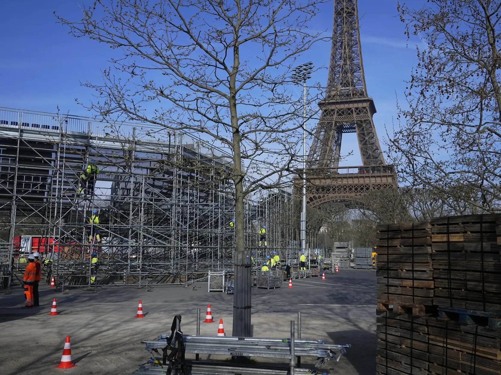 Robotníci stavujú tribúny pre blížiace sa letné olympijské hry na Martovom poli (Champ-de-Mars), verejnom parku v blízkosti Eiffelovej veže v Paríži 25. marca 2024.