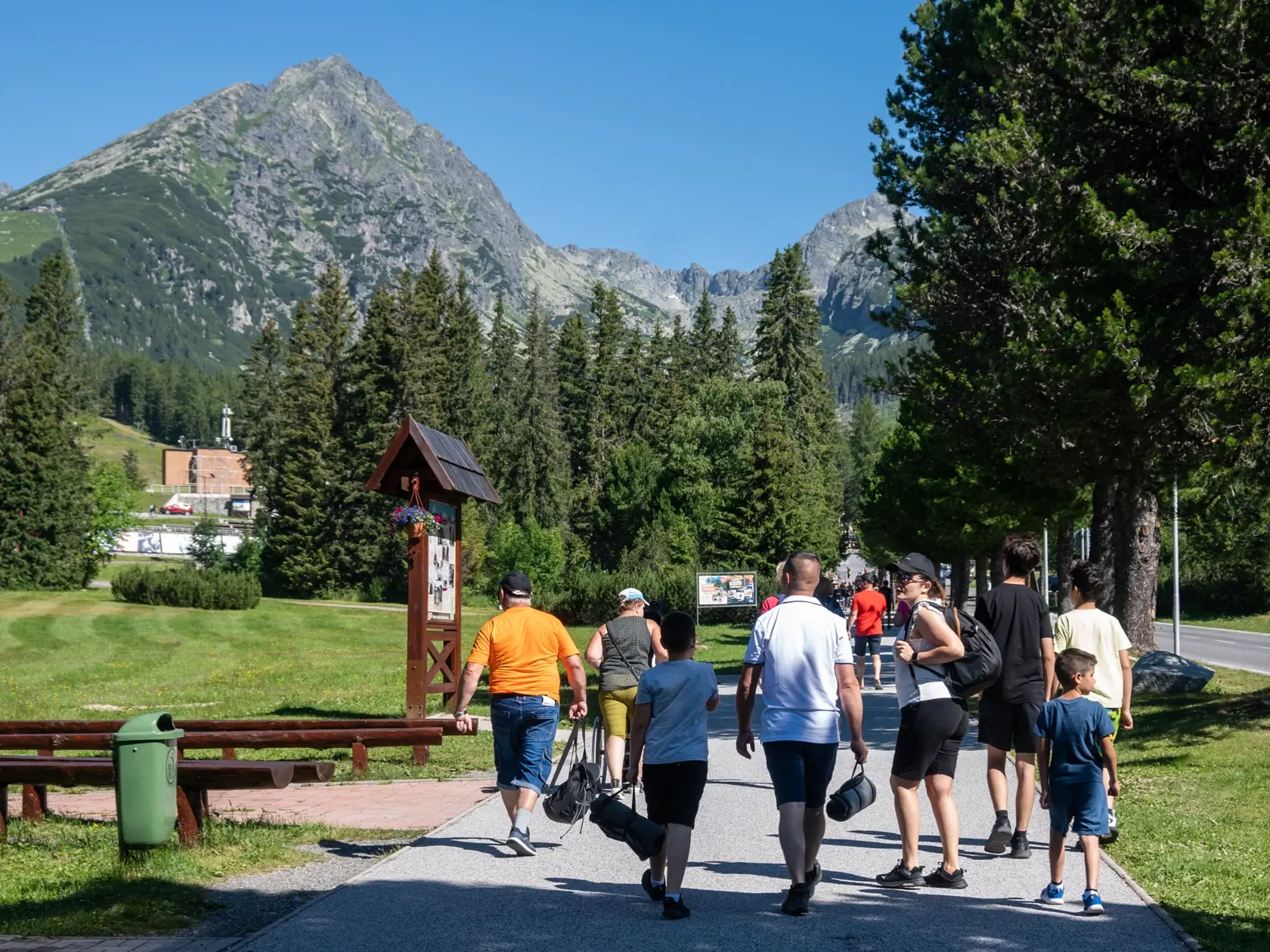 Na snímke turisti kráčajú ulicou K vodopádom, v pozadí Predné Solisko, na Štrbskom plese v nedeľu  16. júla 2023. FOTO TASR - Veronika Mihaliková