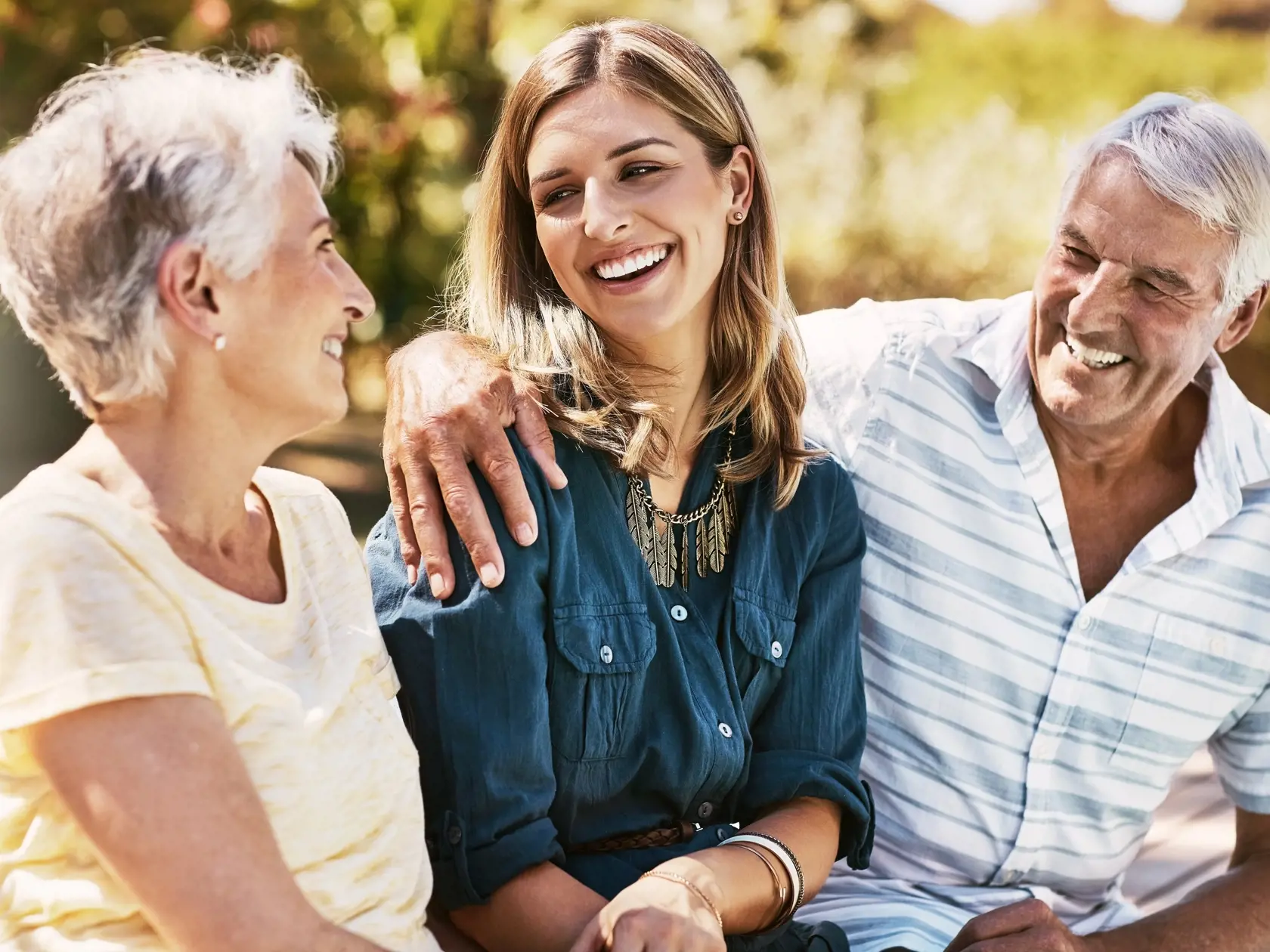 Senior,Parents,In,Nature,With,Their,Adult,Daughter,Sitting,,Talking