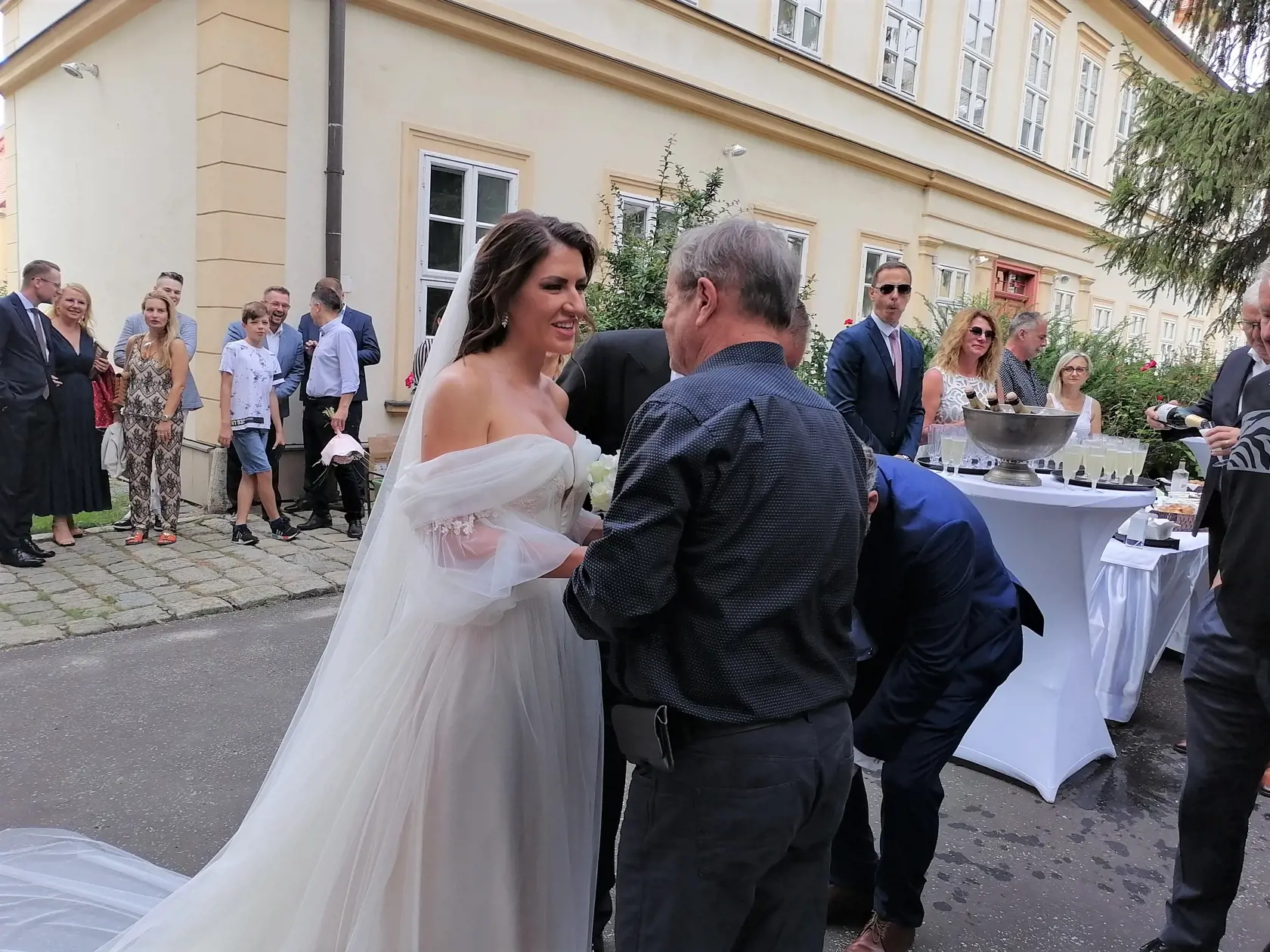 Pred kostolom bolo obrovské množstvo svadobčanov, ktorí sa snažia dostať k mladomanželom a zablahoželať im.