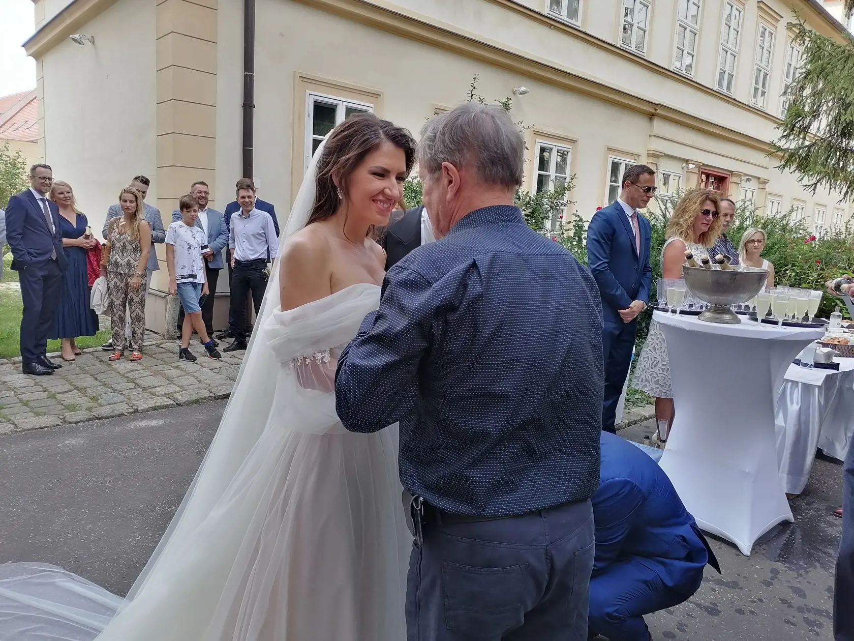 Pred kostolom bolo obrovské množstvo svadobčanov, ktorí sa snažia dostať k mladomanželom a zablahoželať im.