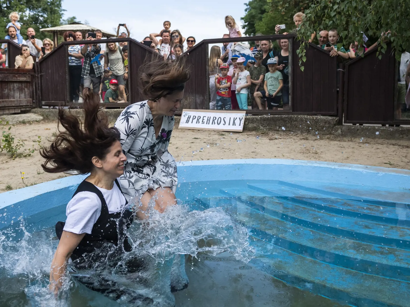 Na snímke zľava štatutárka a predsedkyňa OZ Priatelia Zoo Veronika Vrábelová a riaditeľka bratislavskej Zoo Júlia Hanuliaková skáču do bazéna vo výbehu hrošíkov libérijských počas štartu výzvy #prehrosiky bratislavskej Zoo na vybudovanie lepšieho domova pre hrošíkov libérijských v Bratislave 1. augusta 2022. FOTO TASR - Jaroslav Novák