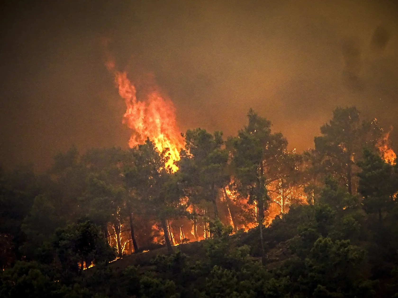 Na snímke lesný požiar na gréckom ostrove R v sobotu 22. júla 2023. Veľký lesný požiar horiaci na gréckom ostrove Rhodos už piaty deň prinútil úrady nariadiť evakuáciu zo štyroch miest vrátane dvoch prímorských letovísk.