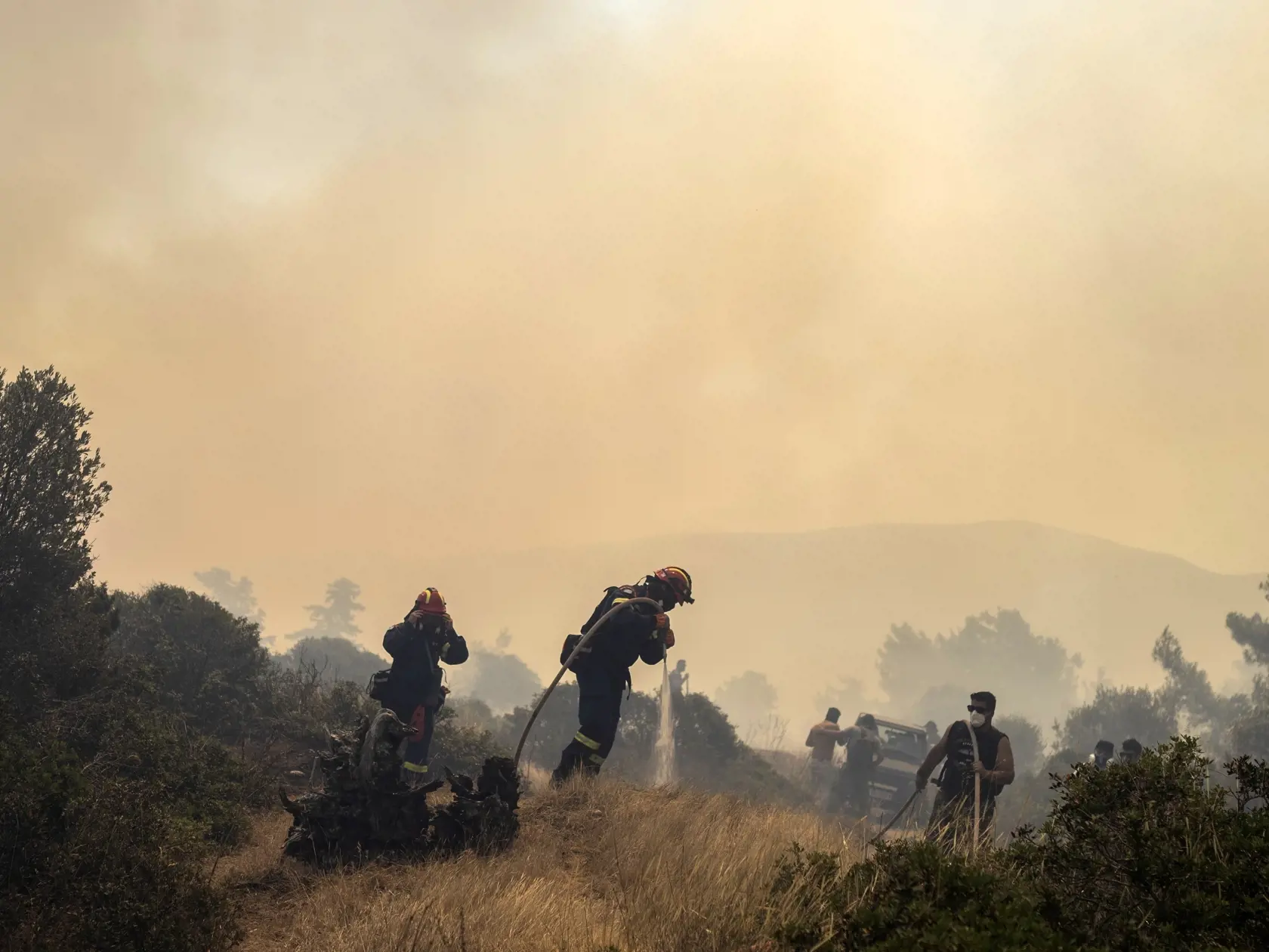 Hasiči zasahujú počas lesného požiaru v obci Vati na ostrove Rodos na juhovýchode Grécka v utorok 25. júla 2023. Grécko sa v utorok pripravuje na novú vlnu horúčav, zatiaľ čo na dvoch gréckych ostrovoch vyčíňajú lesné požiare.  Z ostrovov Rodos a Korfu museli počas víkendu evakuovať tisíce miestnych obyvateľov a turistov pred lesnými požiarmi.