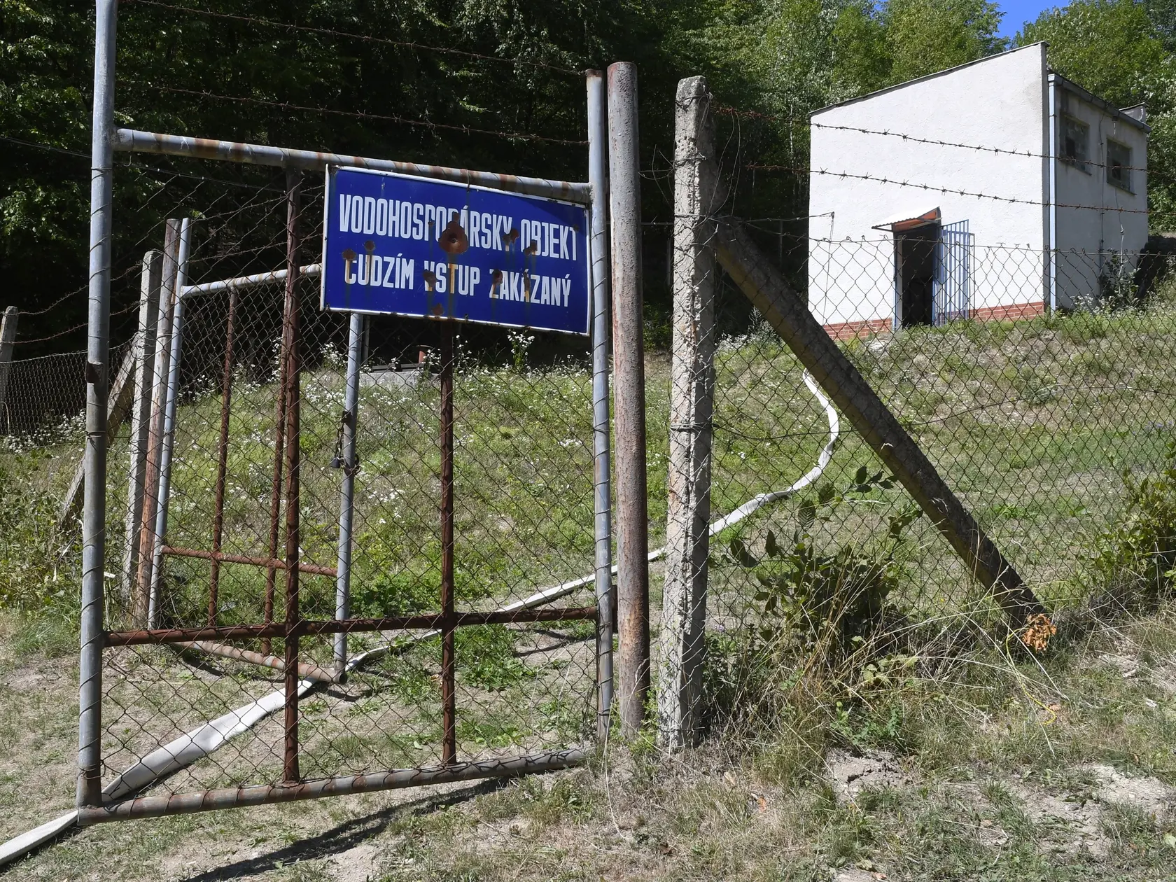 Mimoriadna situácia s nedostatkom vody je v obci Pača, okres Rožňava. Dôsledkom nedostatku zrážok vyschol potok, miestny zdroj vody. V súčasnosti obec zabezpečuje vodu prostredníctvom cisterien, z ktorých sa voda čerpá do vodojemu nad obcou. Okrem vodární im vodu nosia aj dobrovoľní hasiči z obce Plešivec. Na snímke vodojem nad obcou Pača (okres Rožňava) s natiahnutou hasičskou hadicou, cez ktorú vytláčajú vodu z cisterien do vodojemu v piatok 12. augusta 2022. FOTO TASR - Milan Kapusta

