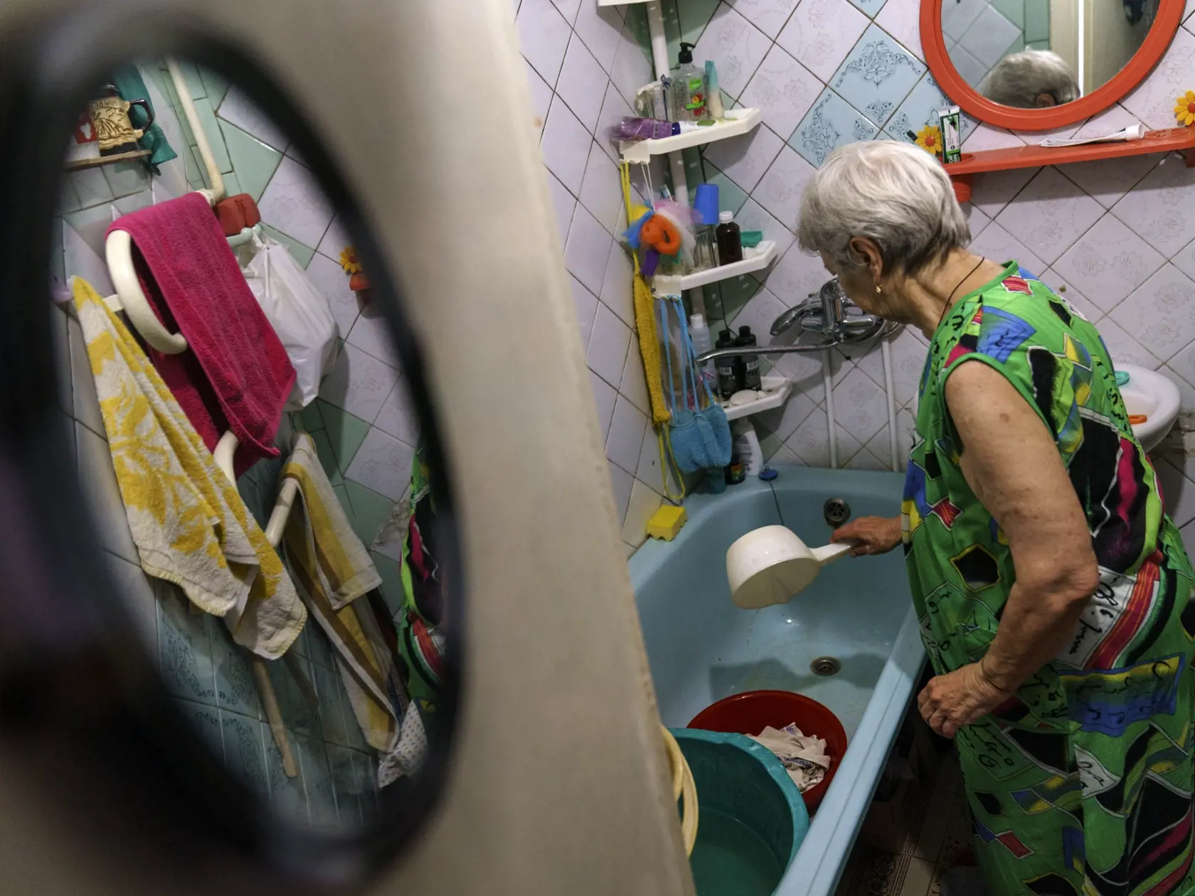 WA 18 Sloviansk - Sedemdesiatšesťročná Ľubov Mahlijová perie uteráky vo vani vodou, ktorú si naberá z verejnej studne v meste Sloviansk v Doneckej oblasti na východe Ukrajiny počas 164. dňa ruskej invázie na Ukrajine v sobotu 6. augusta 2022. "Aj keď počujeme sirény a bombardovanie, stále nosíme vodu," povedala. "Je to pre nás veľké riziko, ale čo môžeme robiť?", dodala. Vodu prevára aspoň 15 minút, aby sa uistila, že je bezpečná na pitie či varenie. Boje medzi ukrajinskými a ruskými silami v bl