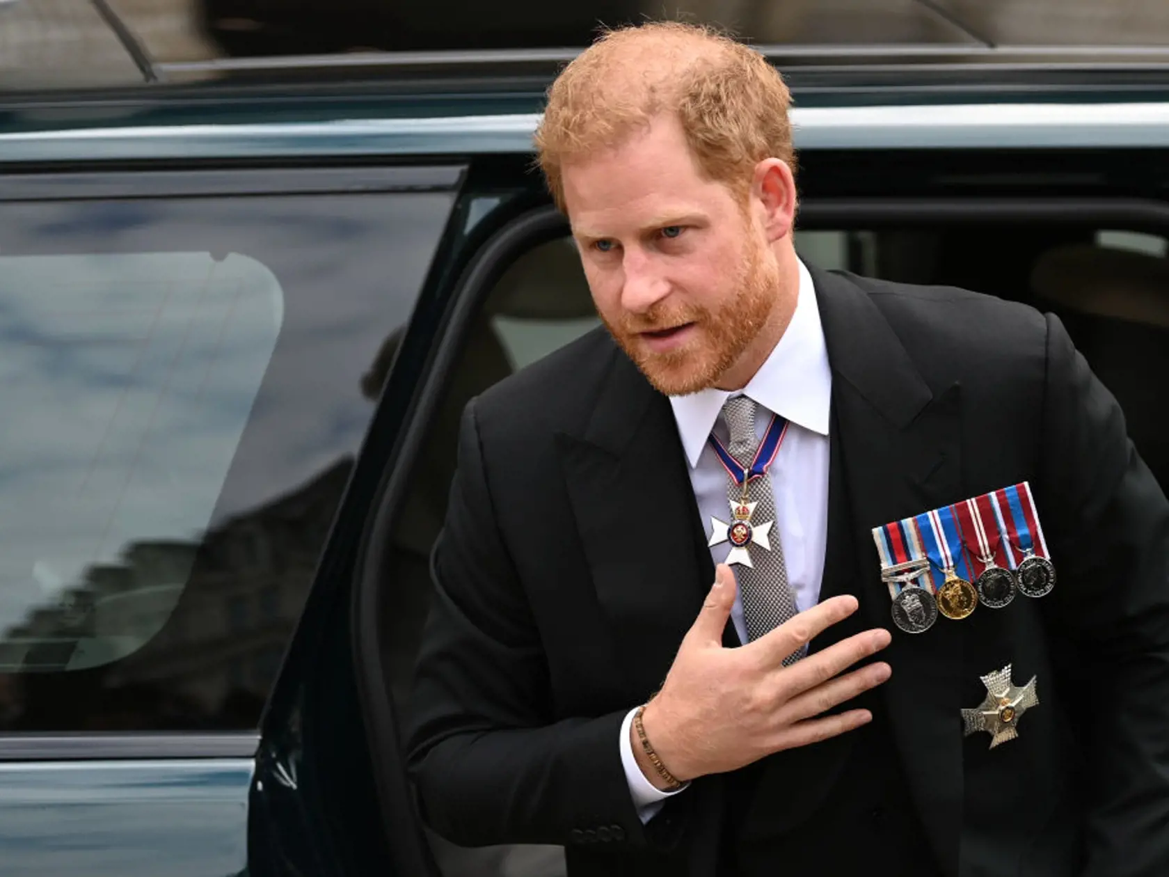 Meghan si pre túto príležitosť zvolila biele šaty a ladiace biele sako spolu s elegantným bielym klobúkom. Princ Harry prišiel na bohoslužbu v elegantnom obleku, ktorý mu na hrudi zdobili vojenské vyznamenania.