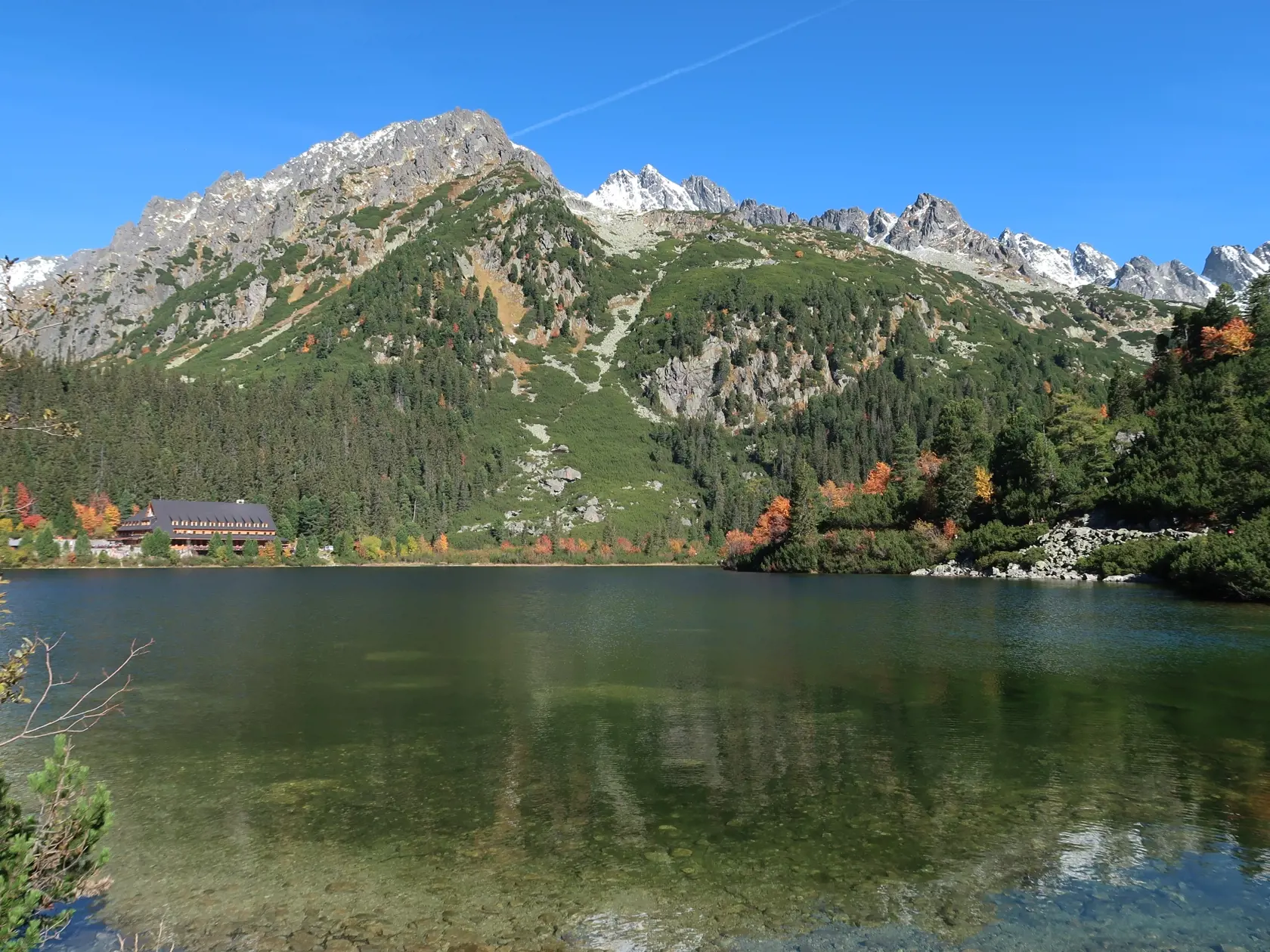 Babie leto v Tatrách si užívalo cez víkend množstvo turistov. Na snímke pohľad na jesenné Popradské pleso obklopené zasneženými vrcholmi Tatier v sobotu 8. októbra 2022. FOTO TASR - Adriána Hudecová