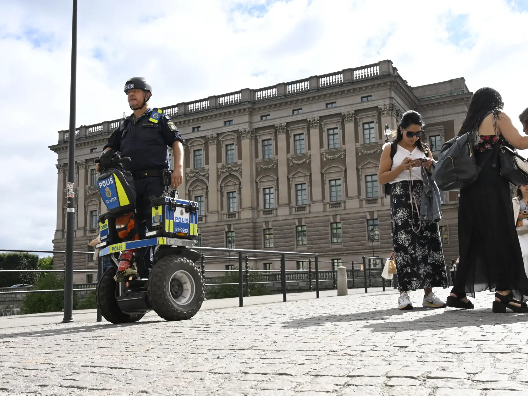 Policajt hliadkuje pred parlamentom v Štokholme vo štvrtok 17. augusta 2023.
