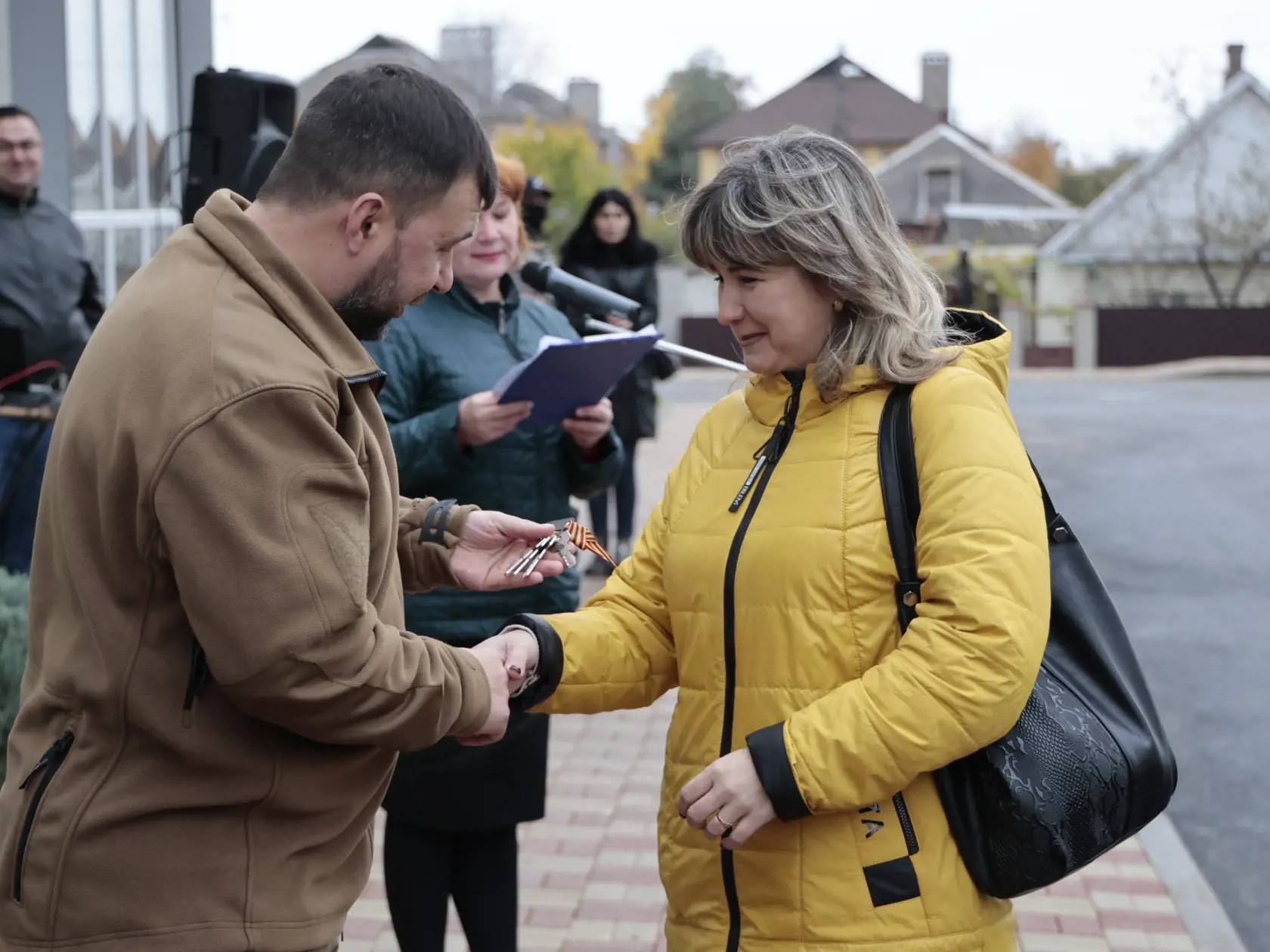 Líder samozvanej proruskej Doneckej ľudovej republiky (DĽR) Denis Pušilin odovzdáva žene kľúče od nového bytu 4. novembra 2022 v ukrajinskom Mariupole.