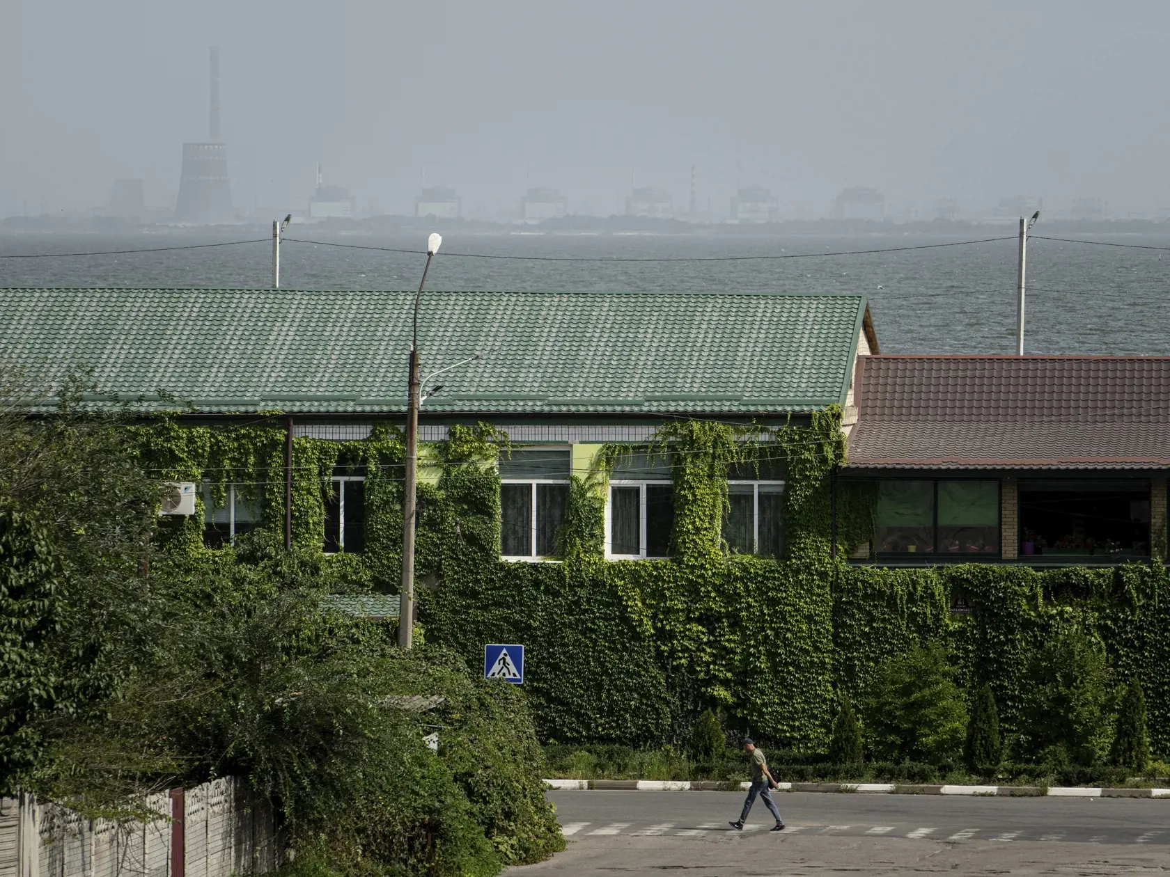 PK 17 archív Nikopol - Na archívnej snímke z 22. augusta 2022 muž prechádza po priechode pre chodcov a v pozadí je viditeľná rieka Dneper a Záporožská jadrová elektráreň v meste Nikopol na juhovýchode Ukrajiny. Všetkých šesť reaktorov Záporožskej jadrovej elektrárne v meste Enerhodar je stále odpojených od elektrickej siete Ukrajiny. FOTO TASR/AP
FILE - A man walks on a pedestrian crossing point near the Dnipro river and Zaporizhzhya nuclear plant on the other side in Nikopol, Ukraine, Aug, 22,