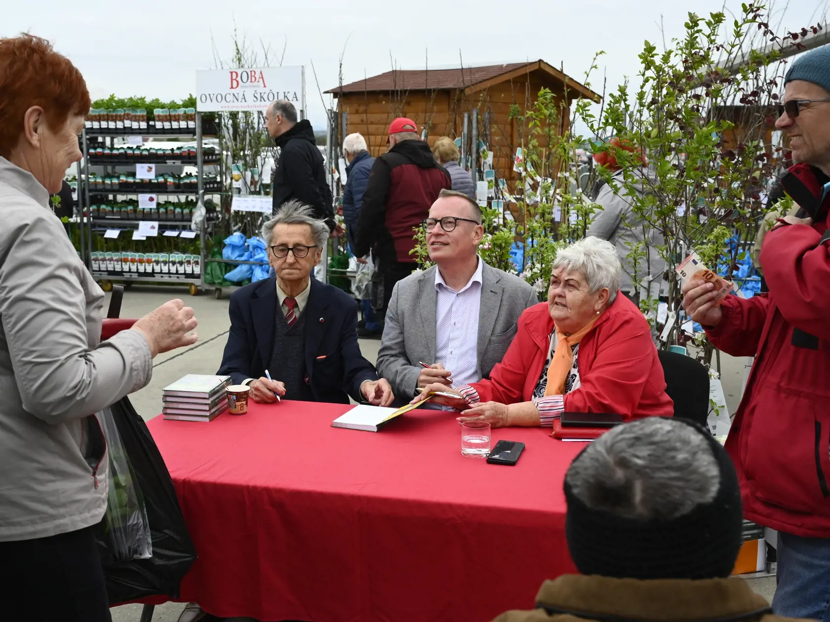Na snímke za stolom zľava pomológ Ivan Hričovský, Marián Komžík a Eva Šidová podpisujú novú publikáciu Pomológia návštevníkom počas záhradkárskeho veľtrhu Záhradkár 2024, 10. apríla 2024 na letisku v Trenčíne. Záhradkársky veľtrh Trenčin sa presťahoval z priestorov výstaviska na trenčianske letisko. Jeho 28. ročník sa začal 10. apríla 2024 a potrvá do nedele 14. apríla. Súčasťou Záhradkárskeho veľtrhu sú veľtrh Záhradkár, včelársky veľtrh a prezentácia ľudových umeleckých remesiel. FOTO TASR - R