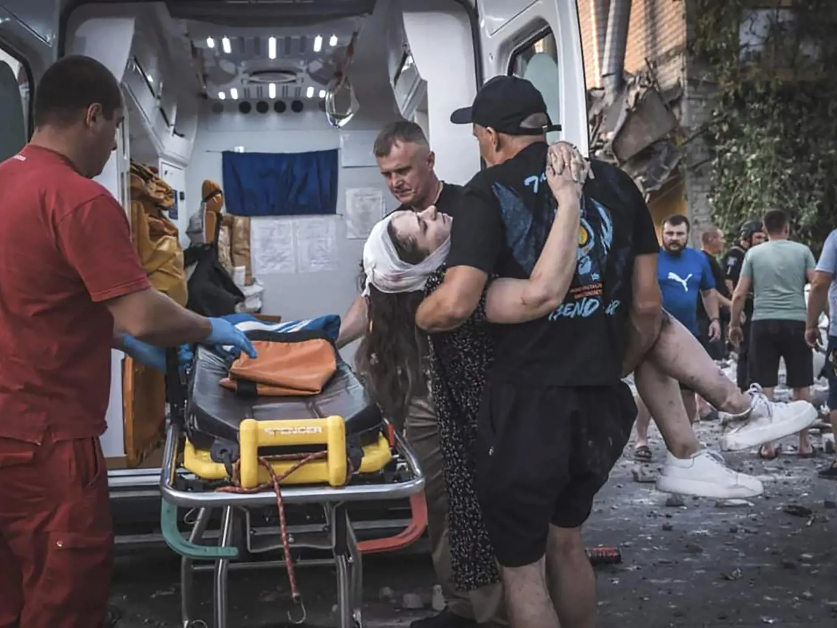 Muž odnáša do sanitky zranenú osobu zo zničenej obytnej budovy po ruskom raketovom útoku v meste Pokrovsk, v Doneckej oblasti na východe Ukrajiny v pondelok 7. augusta 2023.