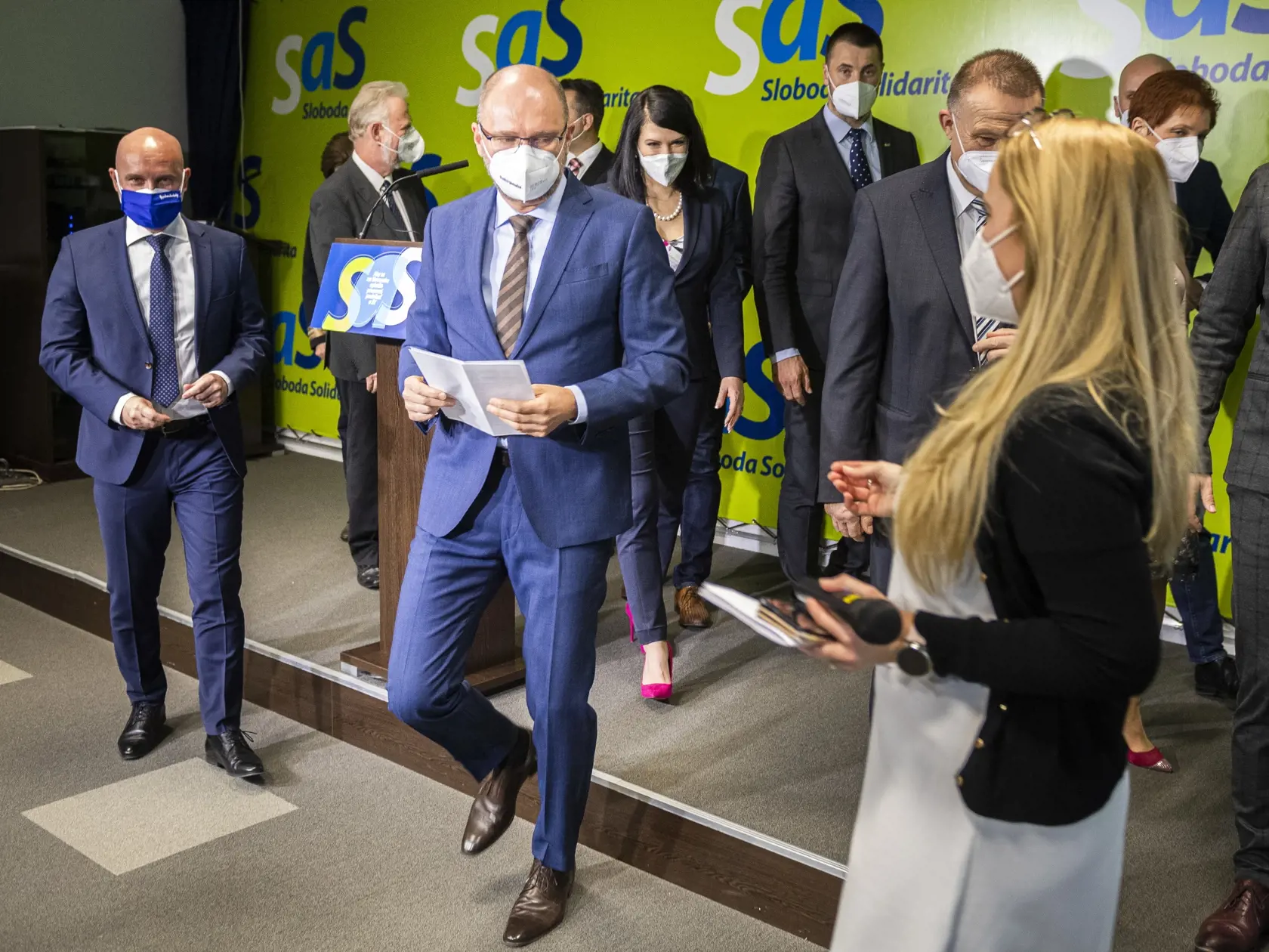 Predseda SaS, podpredseda vlády SR a minister hospodárstva SR Richard Sulík (druhý zľava) odchádza po tlačovej konferencii, na ktorej informoval o tom, že podal demisiu v Bratislave 22. marca 2021. Prvý zľava minister školstva, vedy, výskumu a športu SR Branislav Gröhling.