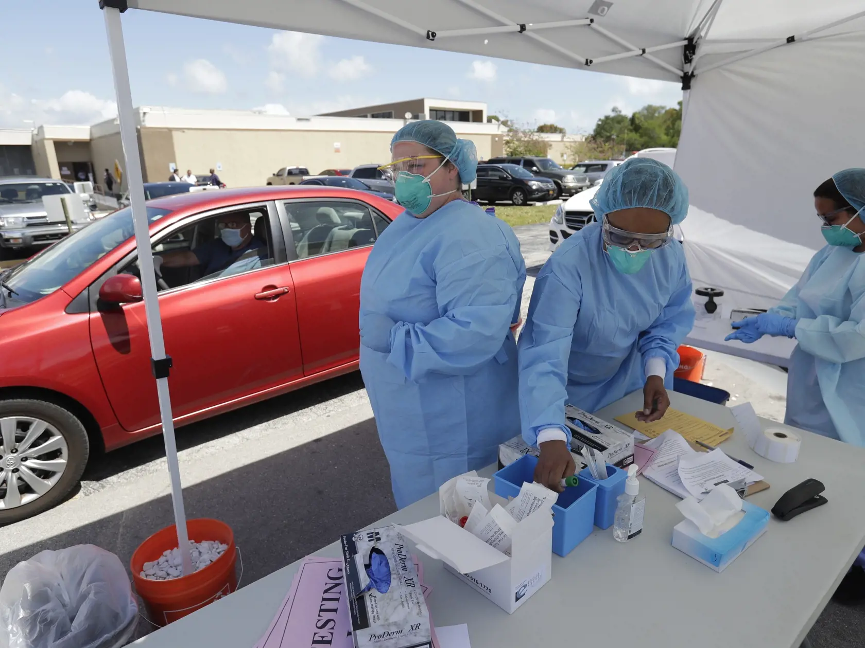 MIK 26 Miami - Zdravotníci čakajú na ďalšie vozidlo pri odbere vzoriek na testovanie na COVID-19 v zdravotníckom centre Doris Ison v Miami na Floride 20. marca 2020. Škody, ktoré spôsobí nový koronavírus na trhu práce v USA, môžu byť bezprecedentné. Podľa ekonómov počet nových ľudí bez práce prelomí všetky doterajšie rekordy. FOTO TASR/AP

Healthcare workers wait for the next car after testing driver Carlos Garcia at a drive-through testing site for COVID-19, the disease caused by the new corona