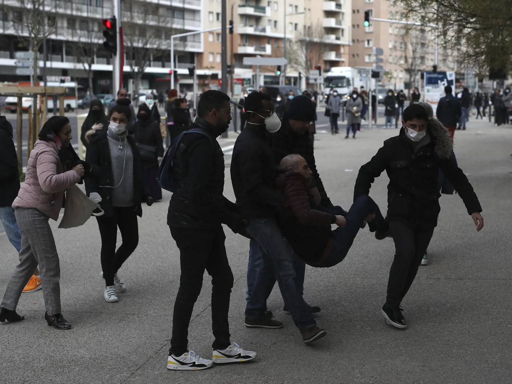 MIK 14 Marseille - Ľudia nesú muža, ktorý spadol kým čakal v rade na test na koronavírus v Marseille vo Francúzsku 23. marca 2020. Francúzsky parlament v nedeľu 22. marca 2020 schválil návrh na vyhlásenie "stavu zdravotnej núdze". Toto opatrenie vychádza z legislatívy prijatej po teroristických útokoch vo Francúzsku z roku 2015.

A man is carried away after collapsing while waiting in line to get a Coronavirus test in Marseille, southern France, Monday March 23, 2020. For most people, the new co
