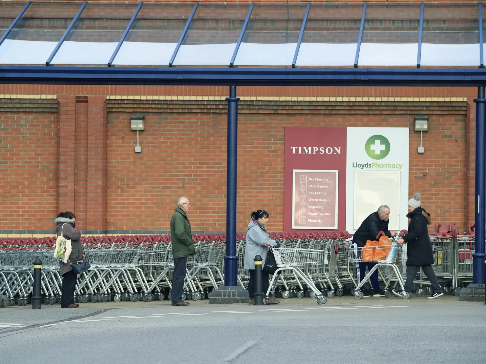 MIK 20 Colton - Ľudia zachovávajú odporúčané vzdialenosti pri čakaní v rade pred supermarketom Sainsbury's v anglickom meste Colton 24. marca 2020. Počet úmrtí na nový koronavírus stúpol v Británii v pondelok, teda za jediný deň, o 54. Celkovo tak v tejto ostrovnej krajine evidujú už 335 obetí na životoch. Premiér Boris Johnson zvažuje zavedenie prísnejších opatrení na spomalenia šírenia vírusu, keďže tisíce ľudí v Británii ignorujú príslušné odporúčania vlády. FOTO TASR/AP

People observe socia