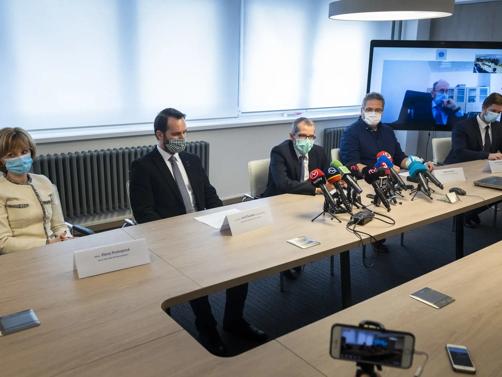 Na snímke zľava hlavná odborníčka Ministerstva zdravotníctva (MZ) SR pre pediatriu Elena Prokopová, garant štandardných diagnostických, terapeutických a preventívnych postupov MZ SR Jozef Šuvada, Radoslav Krupa z Úradu pre riadenie podriadených organizácii MZ SR, krízový manažér pre udalosti s hromadným postihnutím Radoslav Bránik, prezident Slovenskej spoločnosti infektológov Pavol Jarčuška (na obrazovke) a generálny riaditeľ Inštitútu zdravotnej politiky MZ SR Martin Smatana počas tlačovej kon
