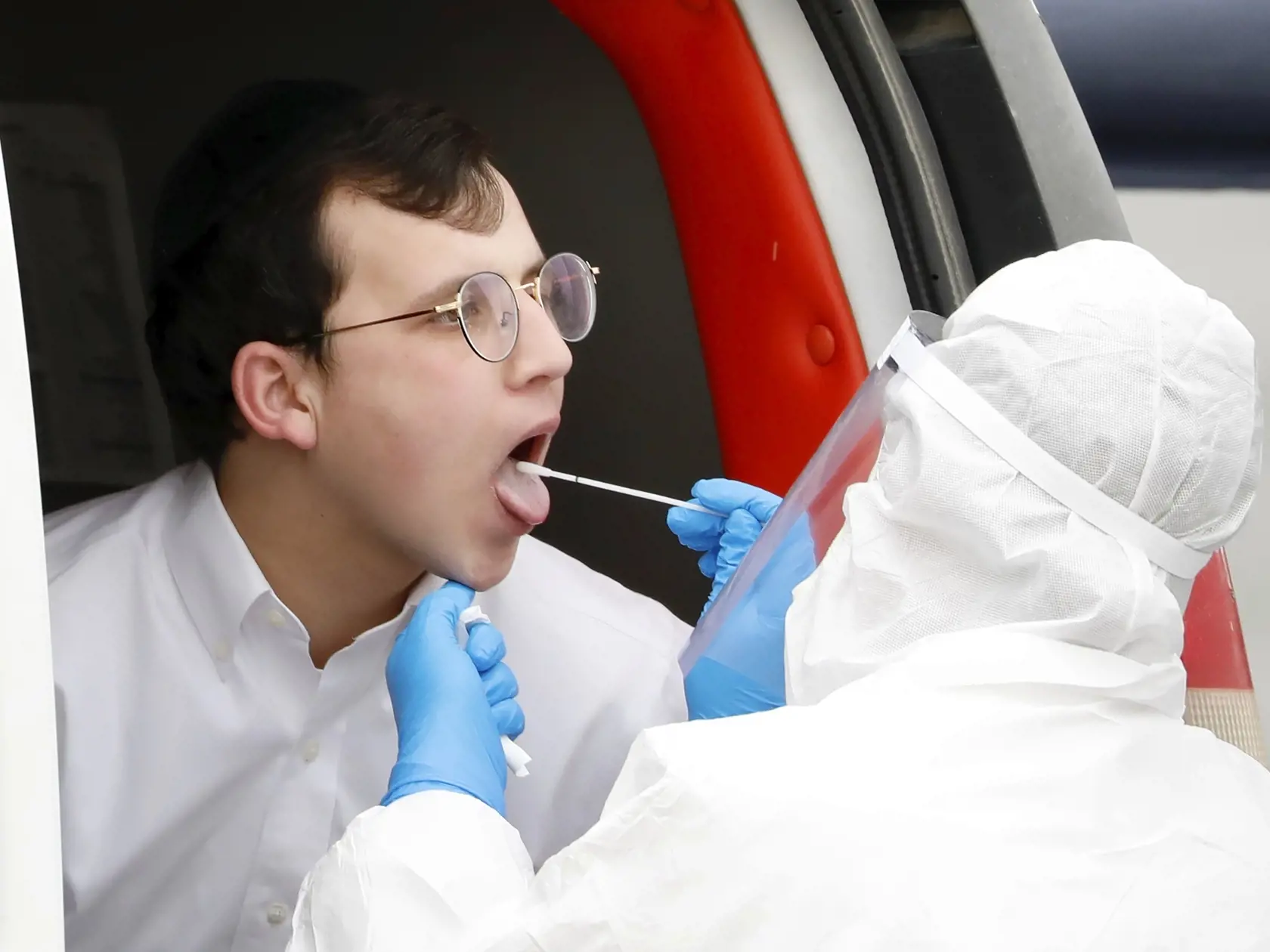 JB 15 Tel Aviv - Izraelský zdravotník v ochrannom odeve robí výter z úst ultra-ortodoxnému mladému Židovi na koronavírus test v rámci nariadení vlády na zabránenie šíreniu nového koronavírusu v Bnei Brak, na predmestí Tel Avivu 31. marca 2020. V Izraeli momentálne evidujú vyše 4347 nakazených. Koronavírus SARS-CoV-2 si tam dosiaľ vyžiadal 15 obetí na životoch. FOTO TASR/AP 

An ultra-Orthodox Jewish young man is tested for COVID-19 by medical personnel wearing protective gear as part of the gove